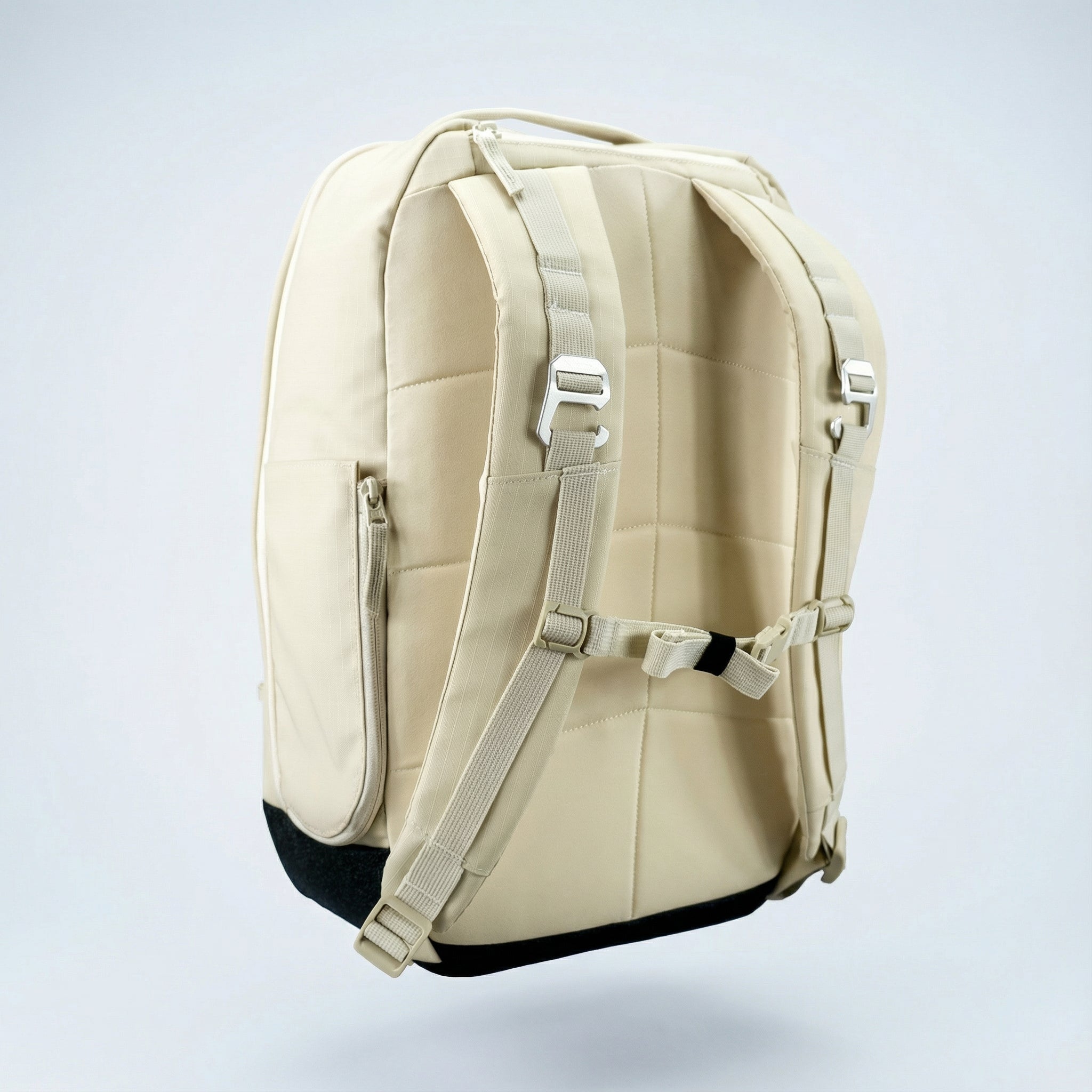 Beige pickleball backpack by FORWRD with padded straps, metal buckles, and black base, seen from the back.