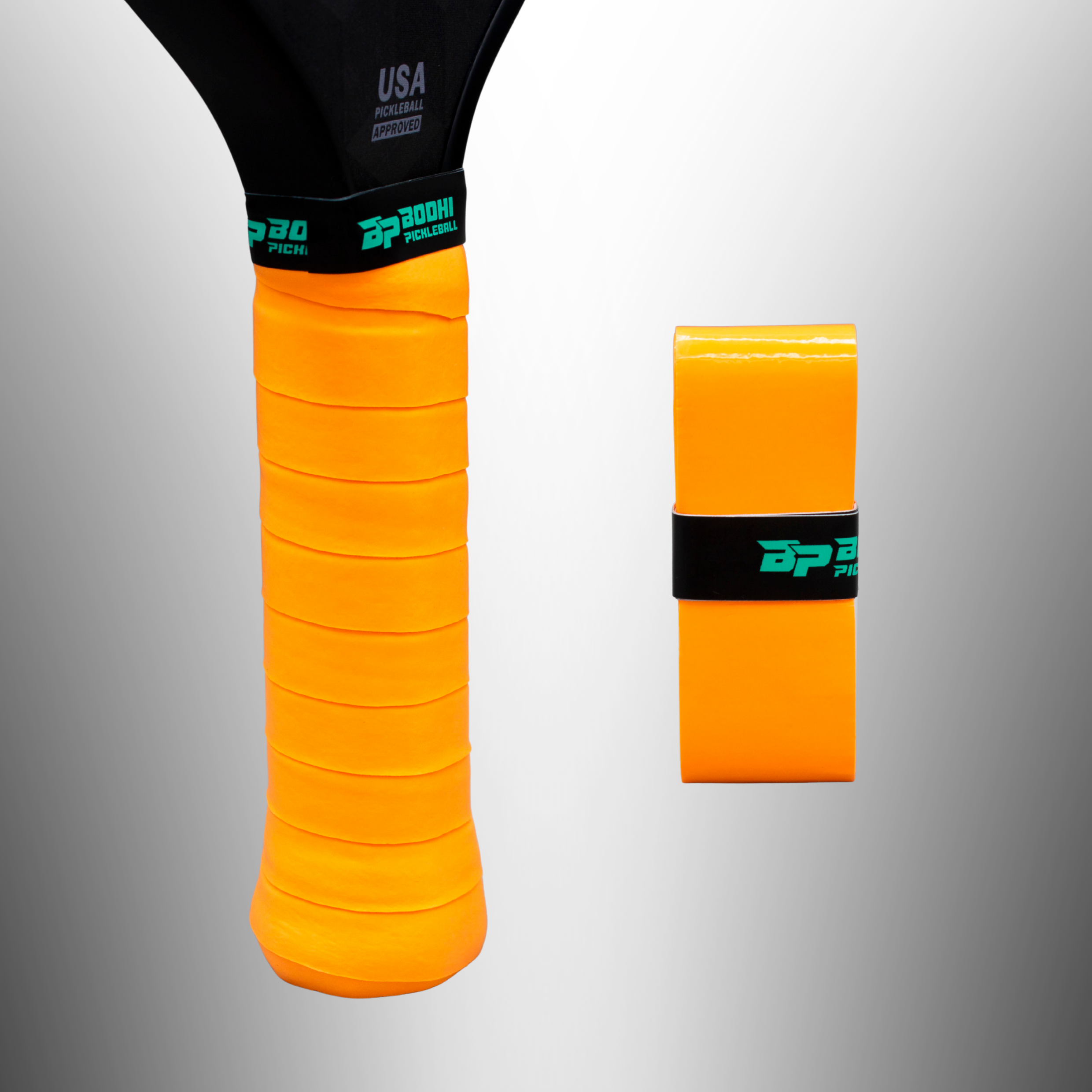 Orange pickleball paddle overgrips by Bodhi Pickleball, one on a black paddle handle, another rolled. Both feature teal logos.