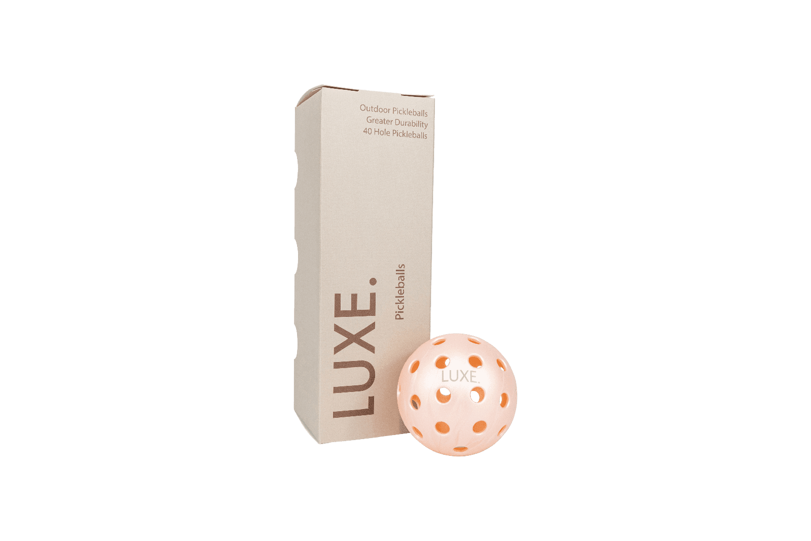 Product shot of a tan box of "LUXE" brand pickleballs next to a "LUXE" pickleball with round holes, against a dark green background.
