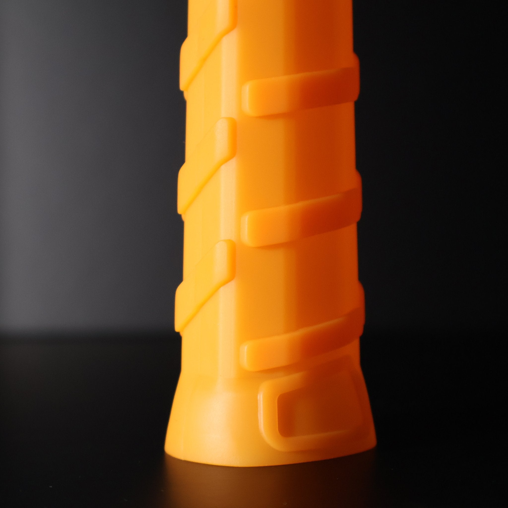 Orange Pro Undergrip by Ethos Pickleball, featuring a ribbed texture, upright on a dark background.
