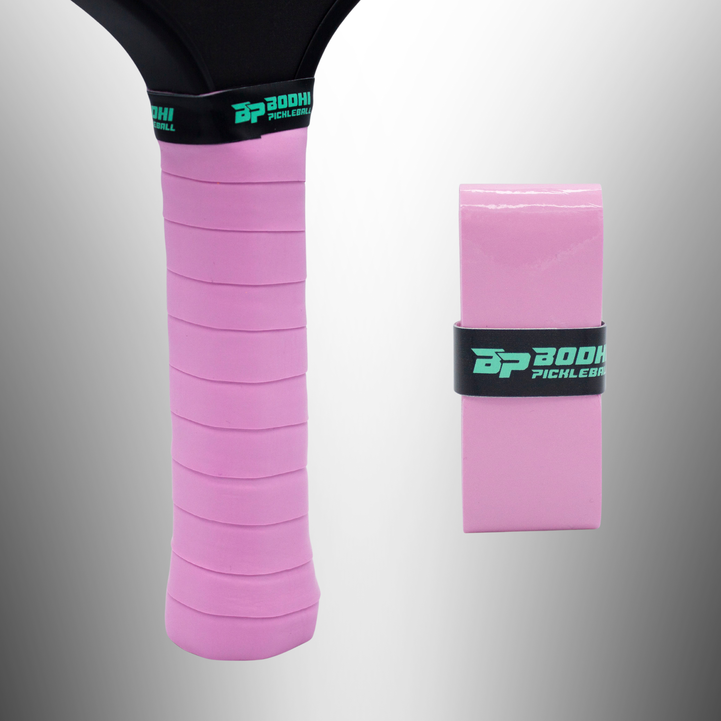 Pink PROtack overgrips by Bodhi Pickleball, one ribbed on a black paddle handle with a green logo band, one unwrapped.