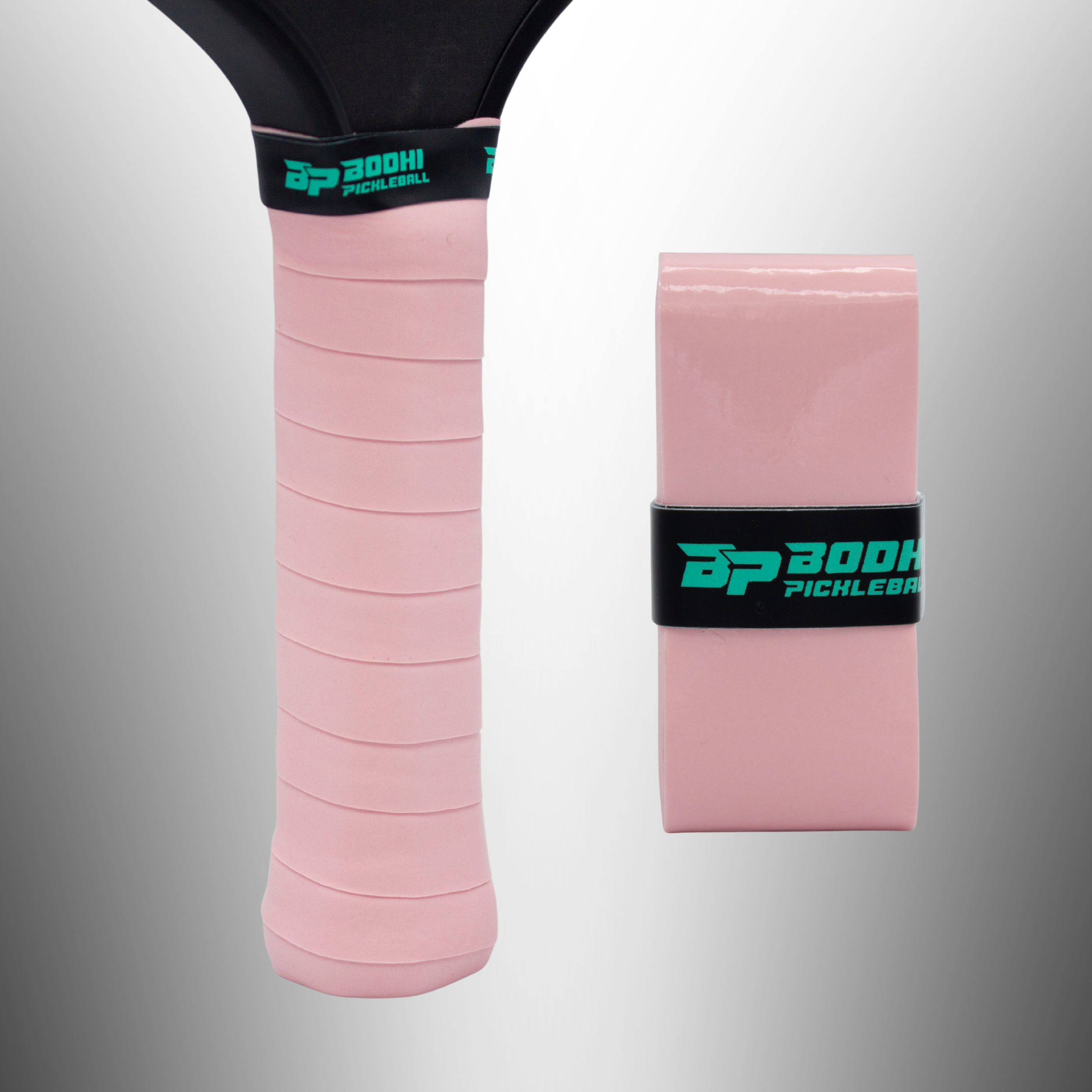 Pink PROtack overgrips by Bodhi Pickleball, one wrapped on a black paddle handle and one rolled, with black and teal logo bands.