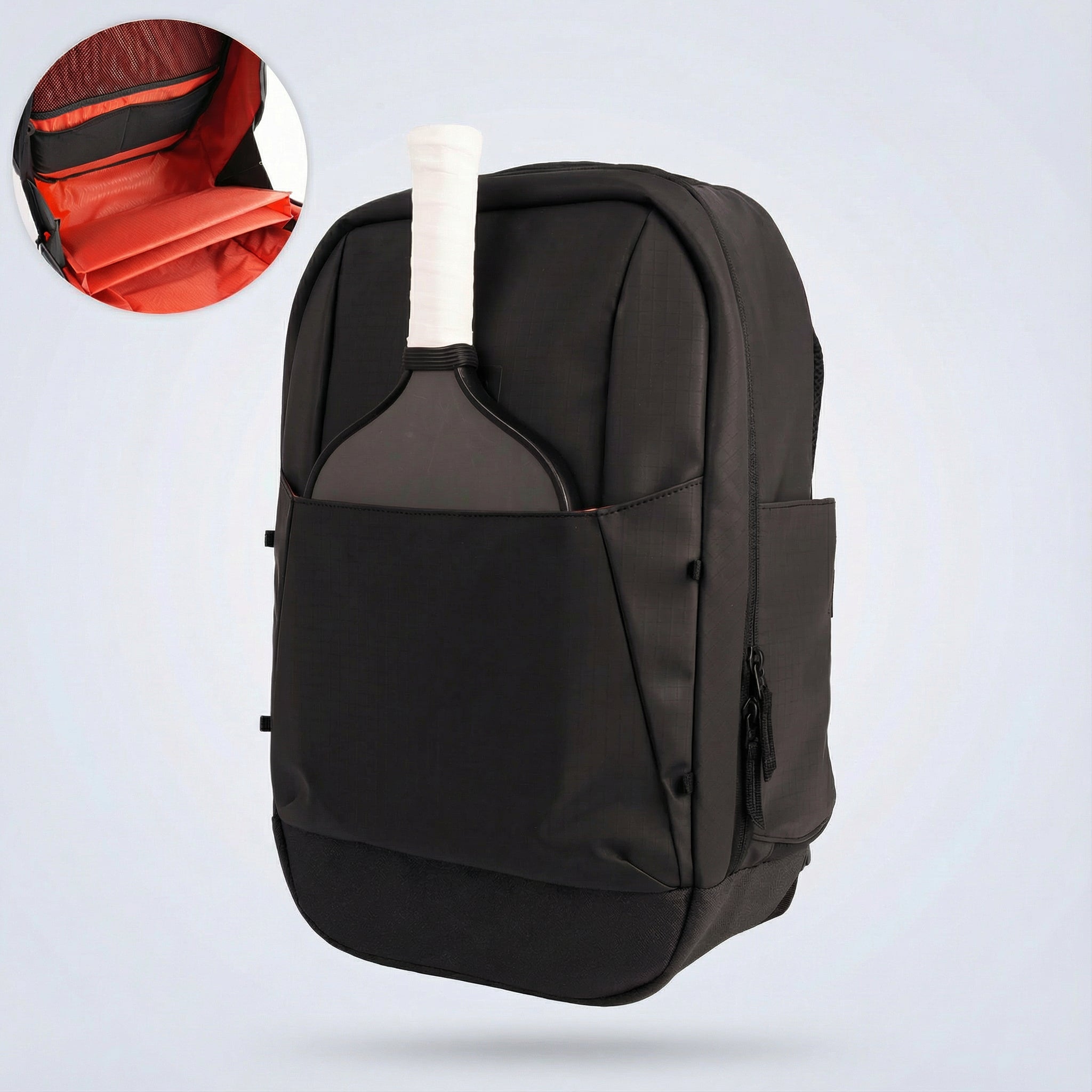 Black pickleball backpack by FORWRD with a pickleball paddle in the front pocket and an inset showing an orange interior.