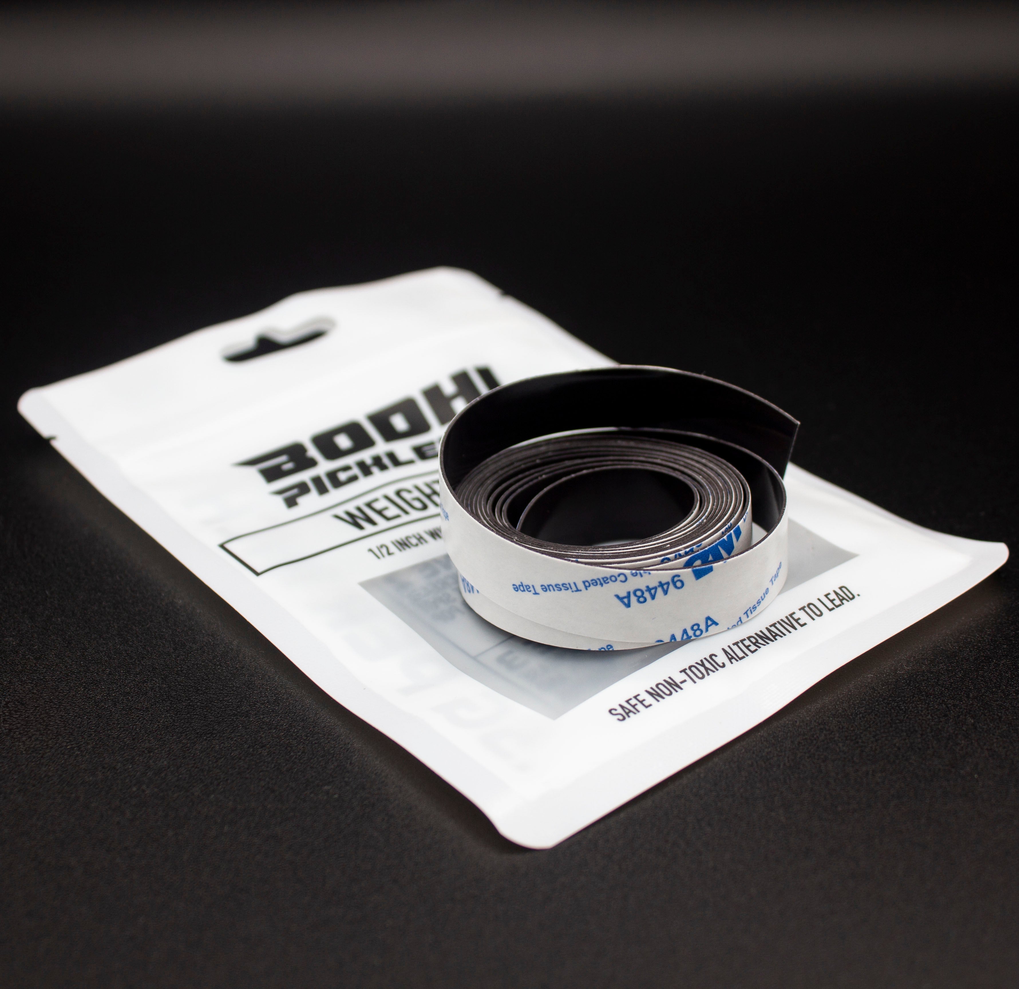 Black pickleball weighted tape, rolled, by Bodhi Performance, on a white pouch stating 'SAFE NON-TOXIC ALTERNATIVE TO LEAD'.