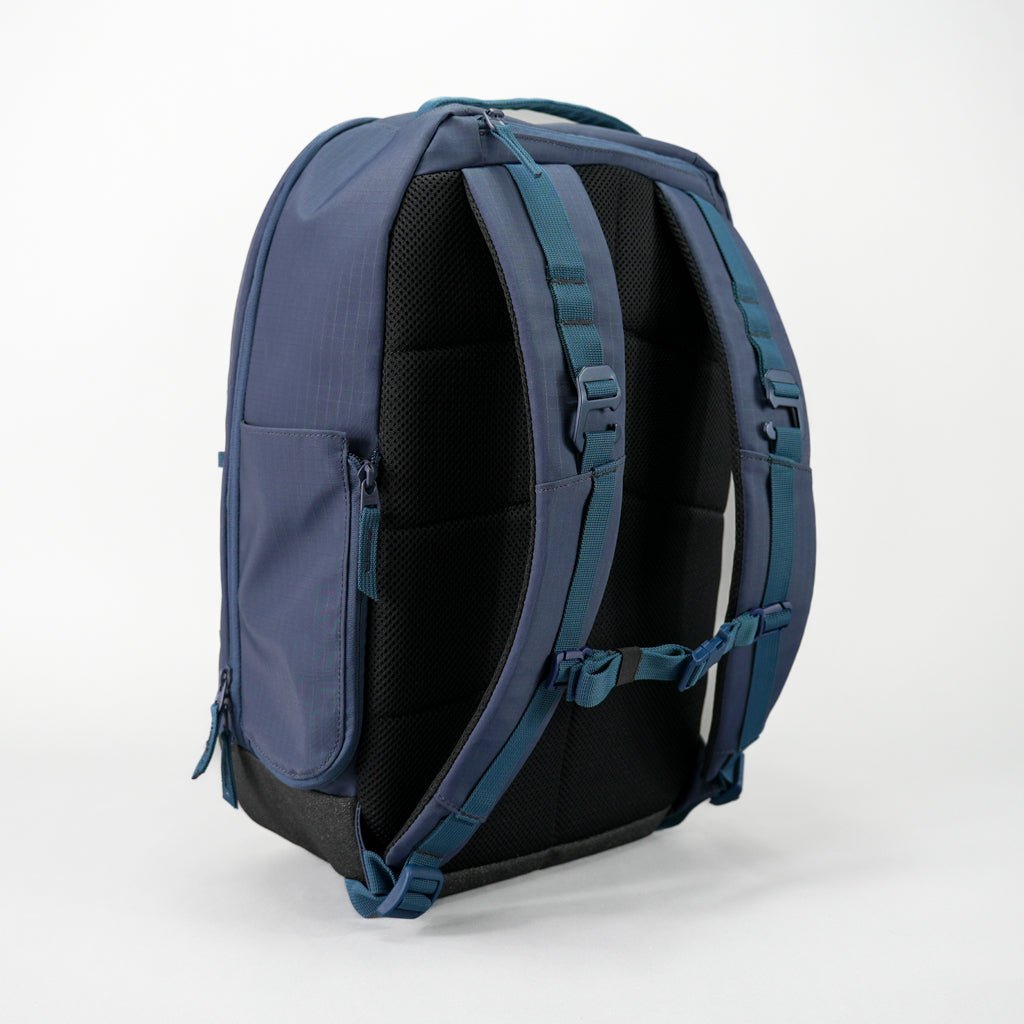 Navy blue textured Pickleball Backpack by FORWRD, with a padded mesh back panel, adjustable straps, and side pocket, shown from the back.