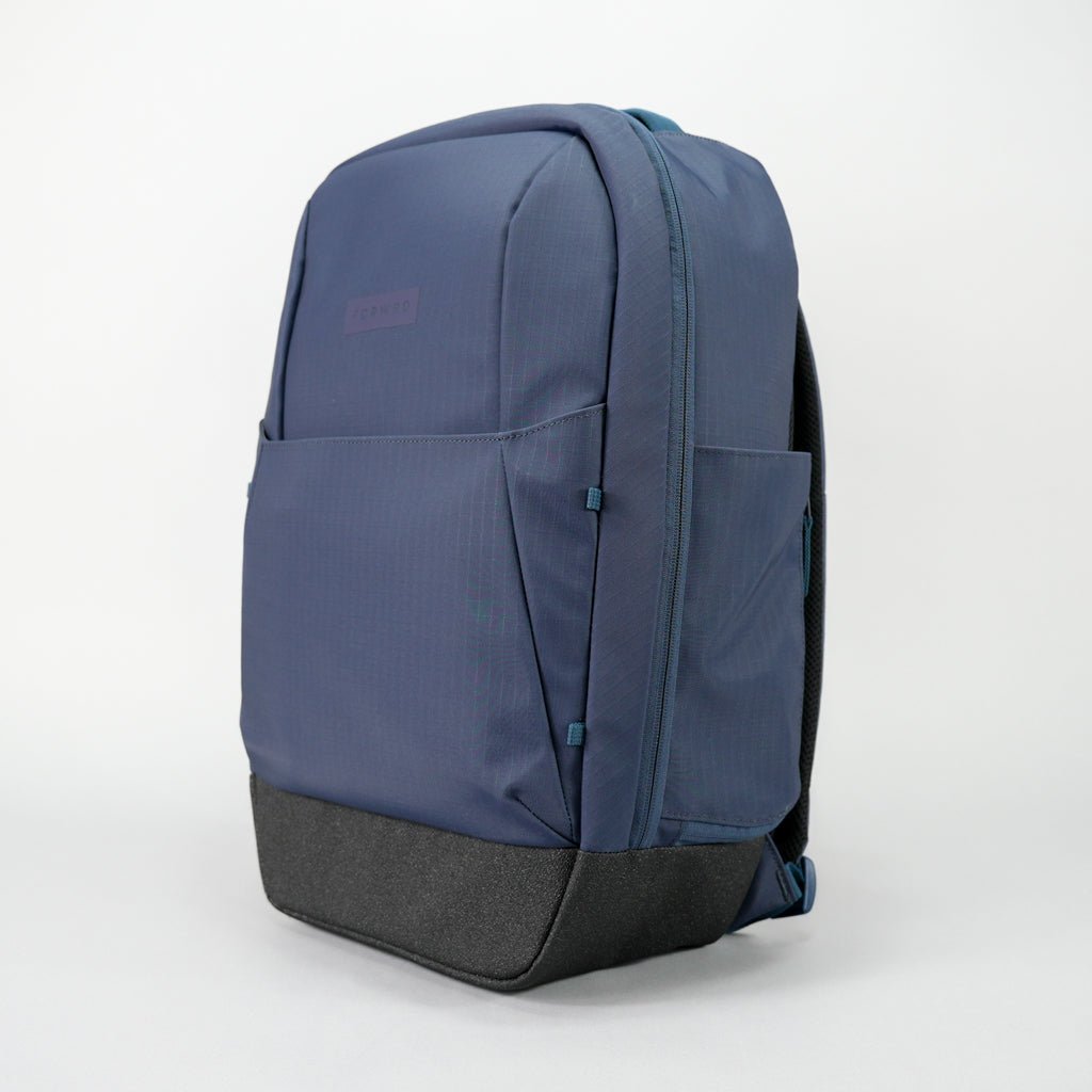 Dark blue pickleball backpack by FORWRD with ribbed fabric, a black textured base, and visible front and side pockets.