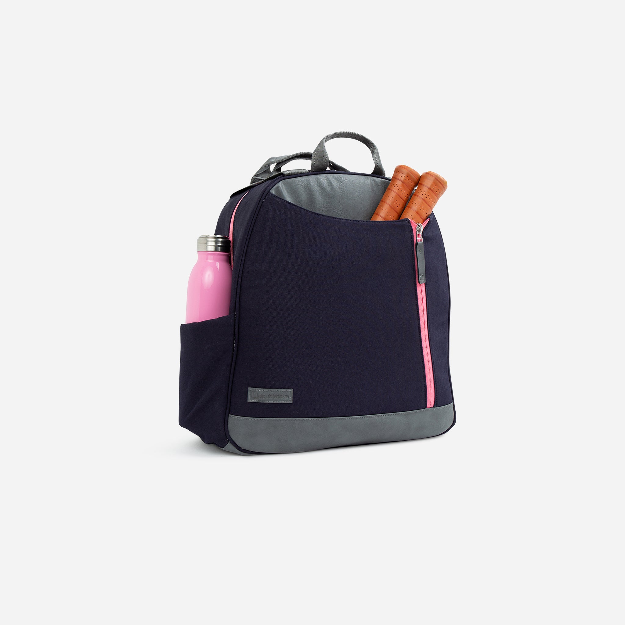 A navy blue and grey sporty backpack by Doubletake, with pink zipper accents, holding a pink water bottle and two brown racket handles.
