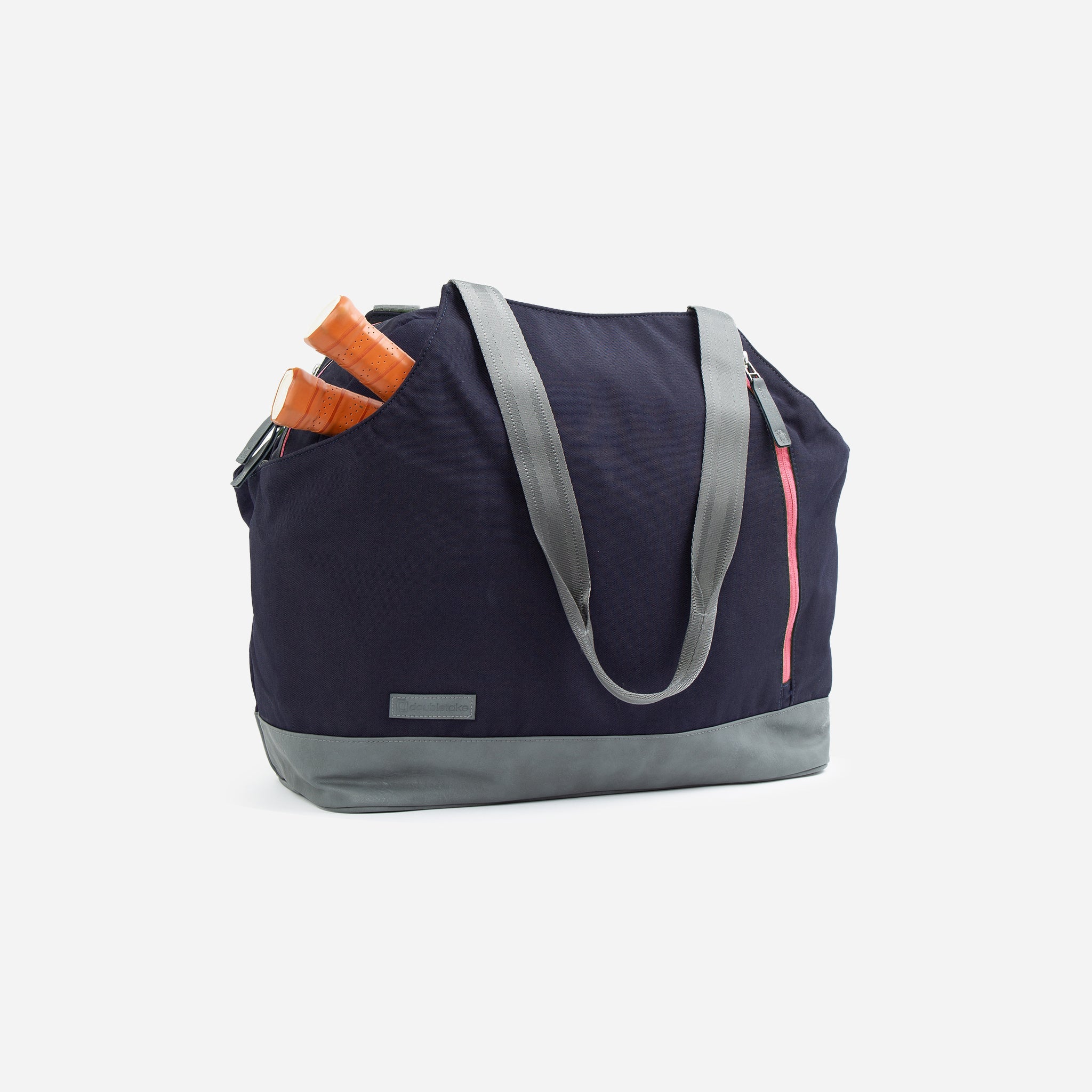 Dark blue pickleball duffel and tote bag by Doubletake with gray base and straps, featuring two orange paddle handles and a pink zipper.