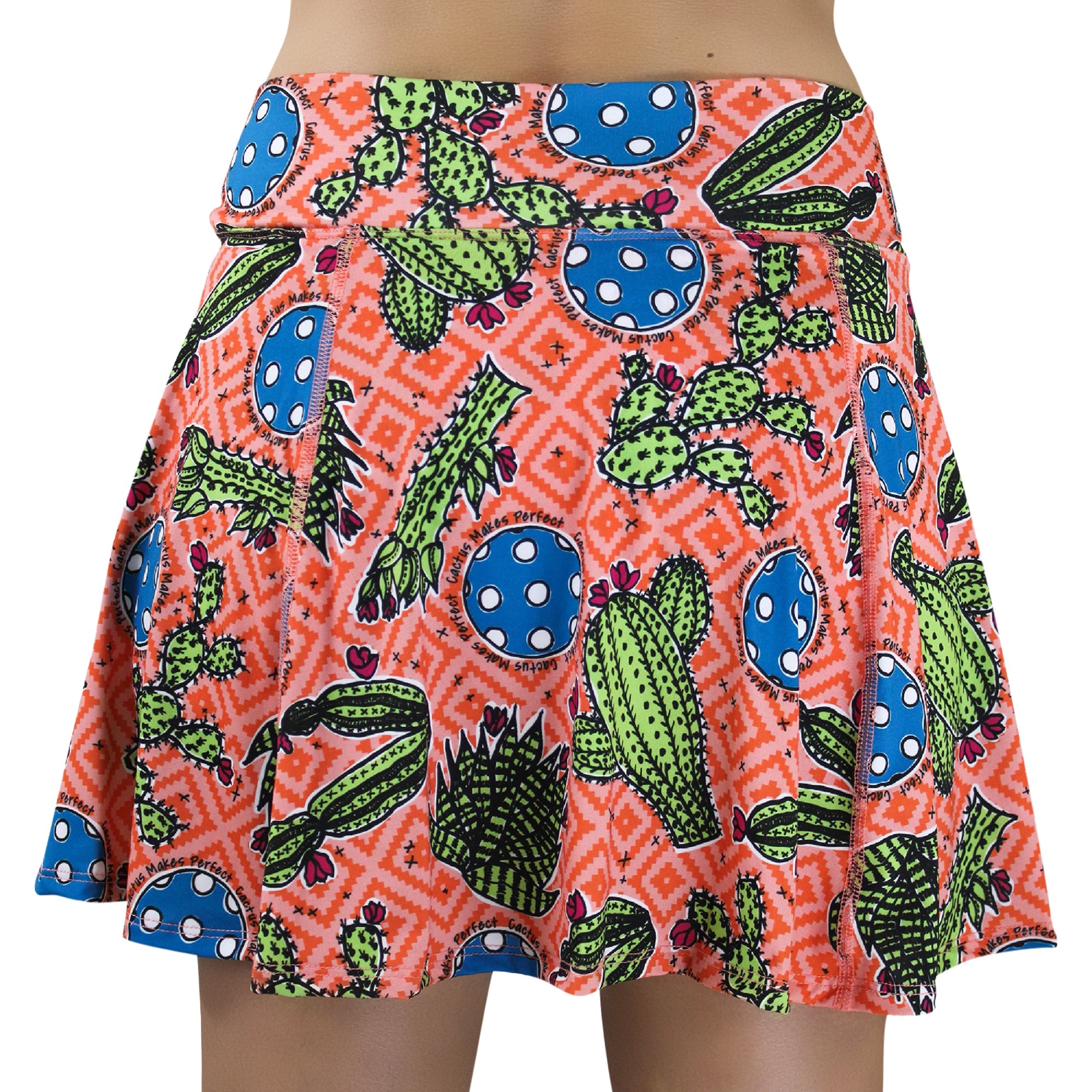 Pink and orange A-line skort by Pickleball Bella, featuring a cactus pattern, blue pickleball circles, and "Cactus Makes Perfect" text.