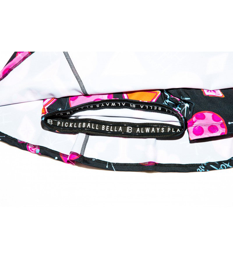 Black A-line skort by Pickleball Bella, featuring colorful martini-themed patterns and an interior branded elastic waistband.