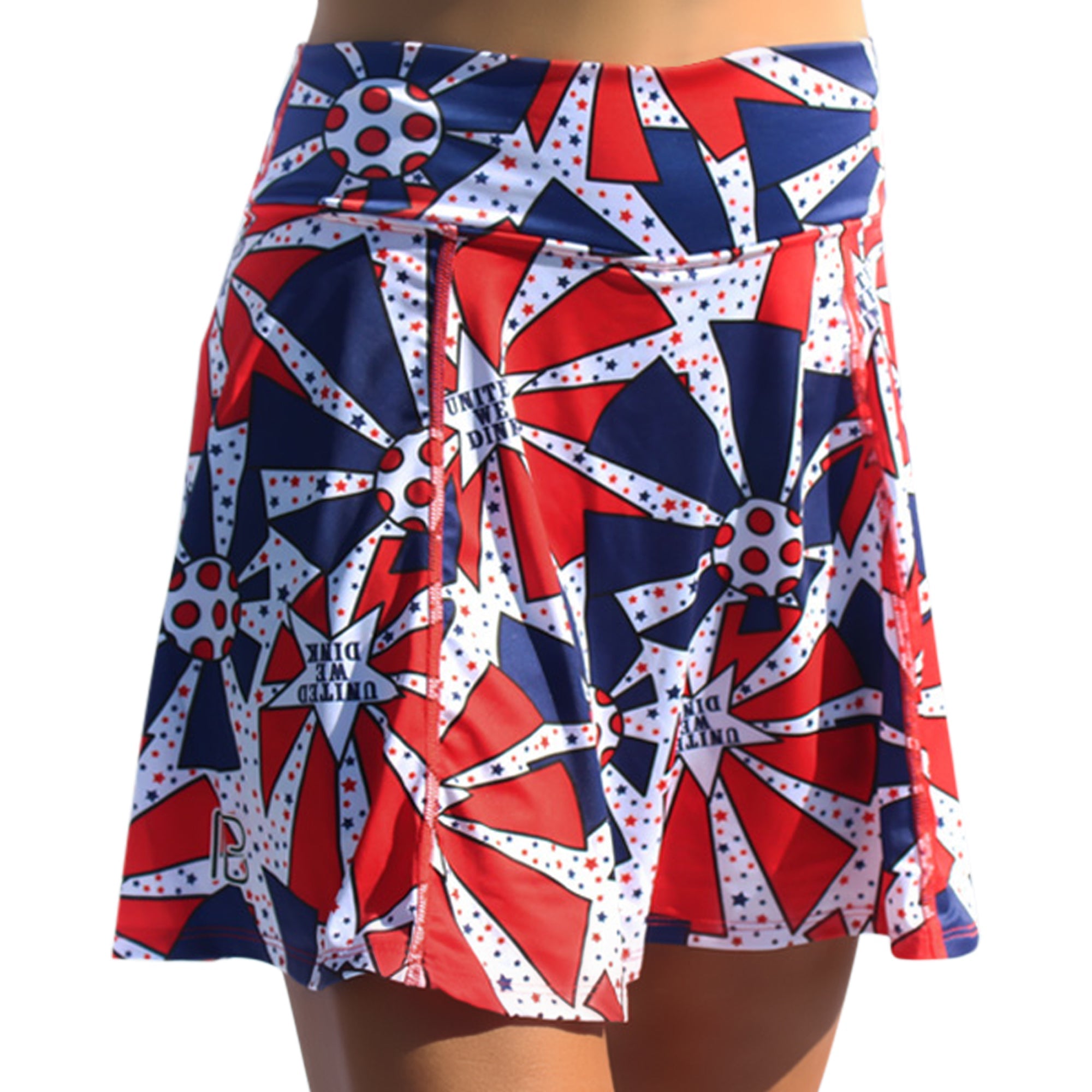Red, white, and blue A-line skort by Pickleball Bella, with star and 'United We Dink' pattern and PB logo, worn frontally.