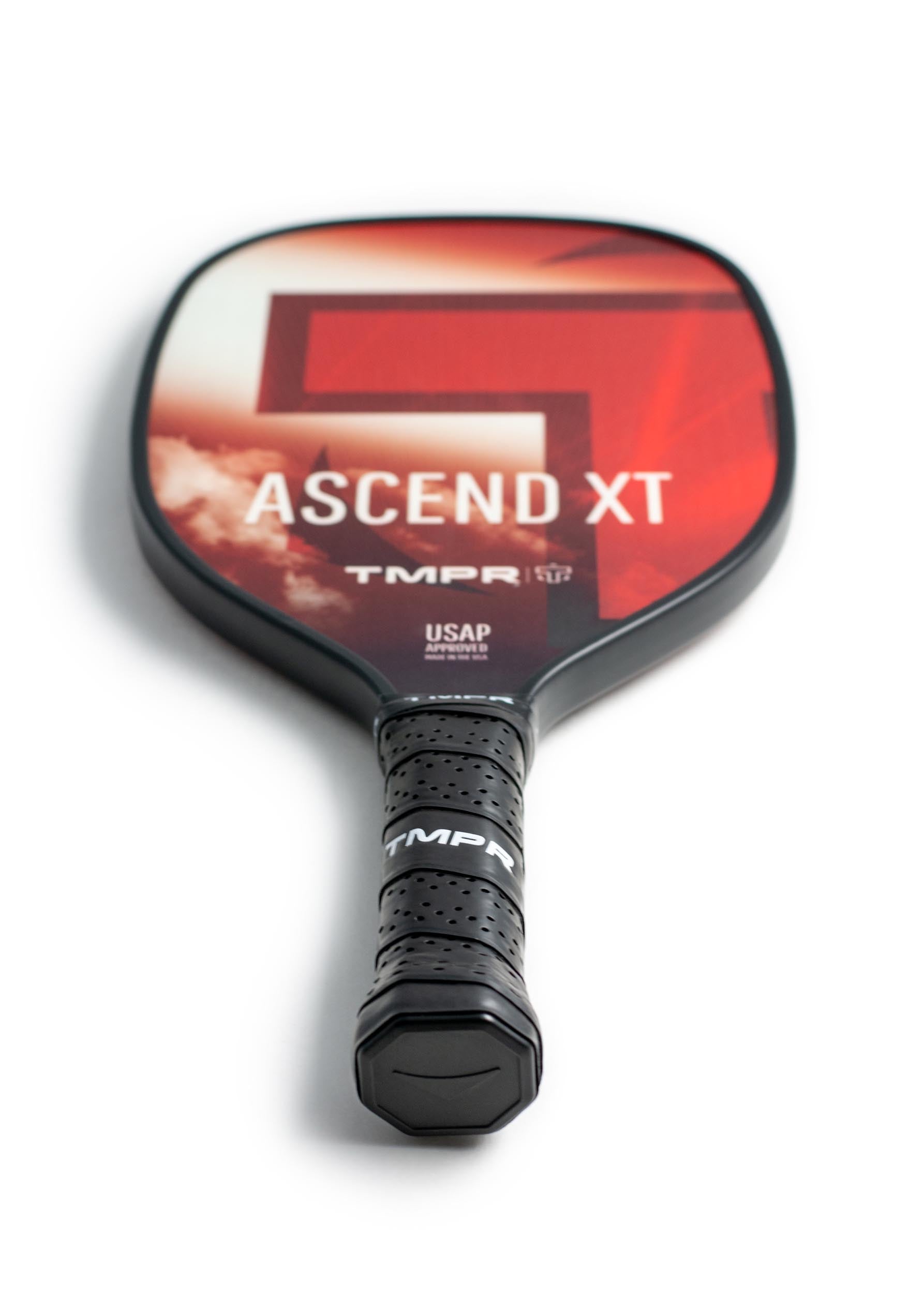 Black-edged pickleball paddle by TMPR Sports with a red cloud-patterned face, white "ASCEND XT" text, and a black perforated grip featuring "TMPR".