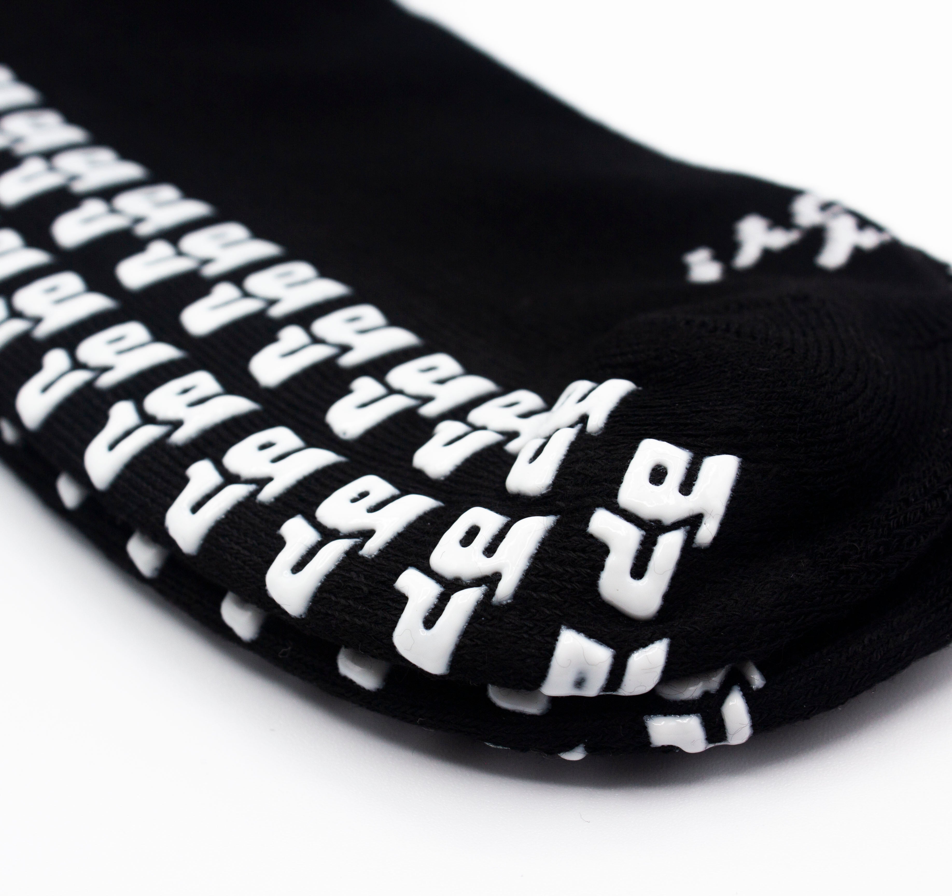 Black performance socks with white, raised GRIPtech™ anti-slip patterns by Bodhi Performance.