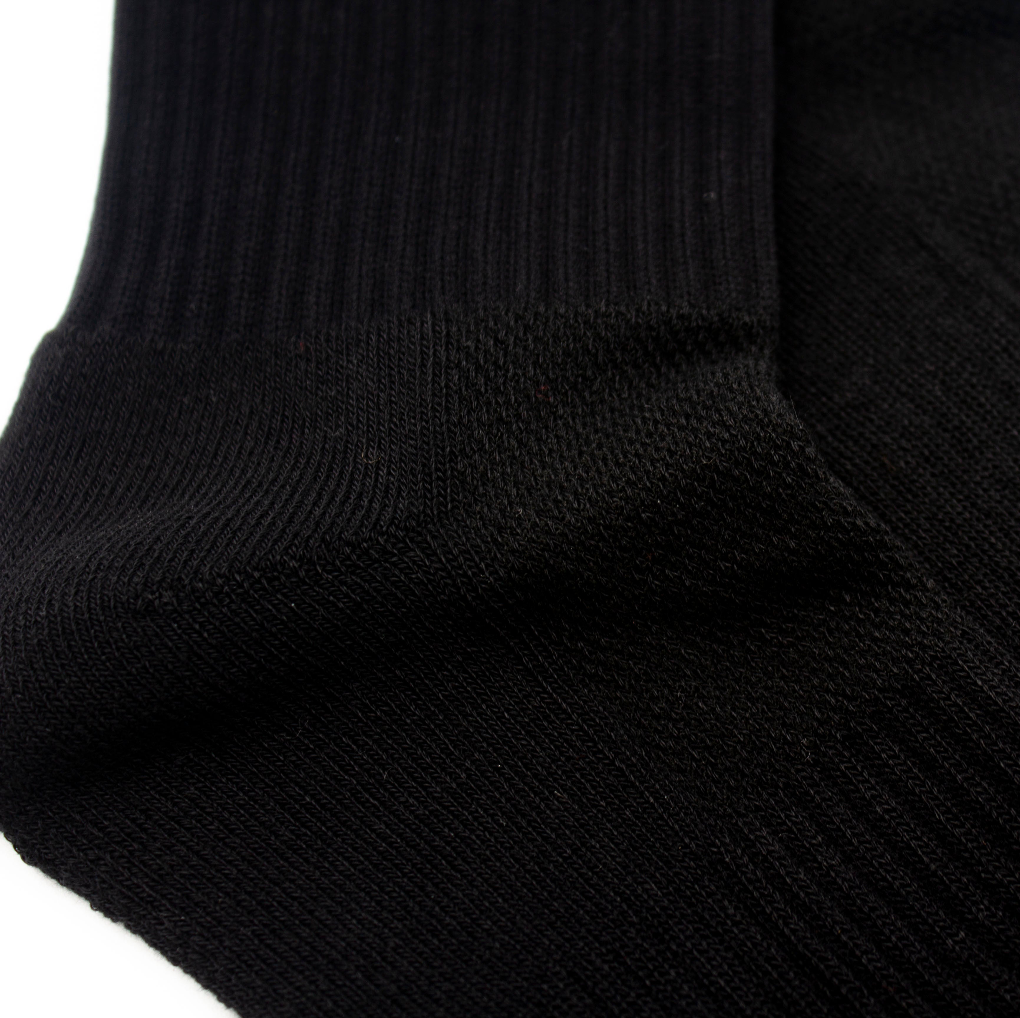 Black performance sock with a ribbed cuff by Bodhi Performance, showing a textured knit foot in a close-up.