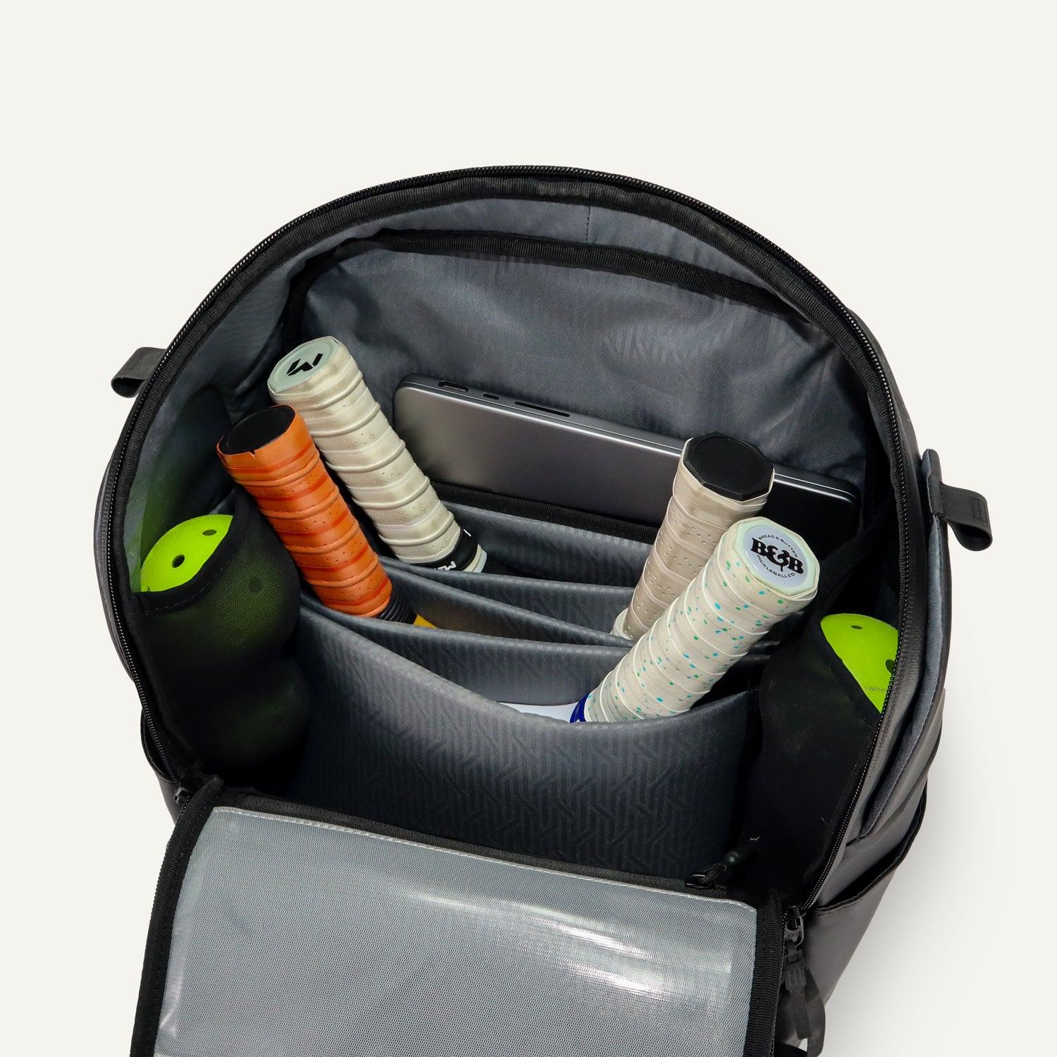 Black Court Caddy Pickleball Bag by FORWRD, open to show organized interior with paddles, balls, and tablet.