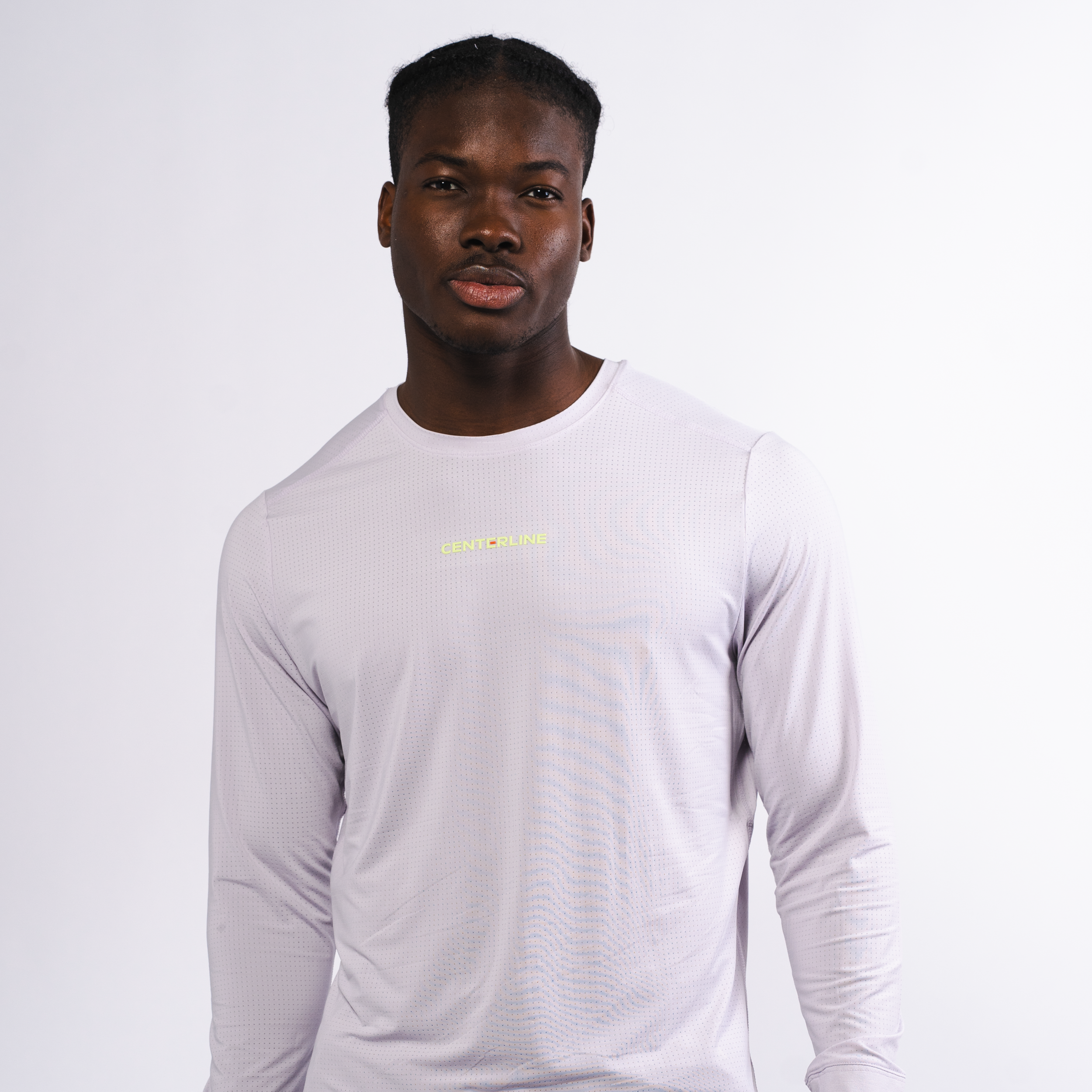 Man wearing a lavender long-sleeved athletic shirt with a perforated texture, standing against a white background.