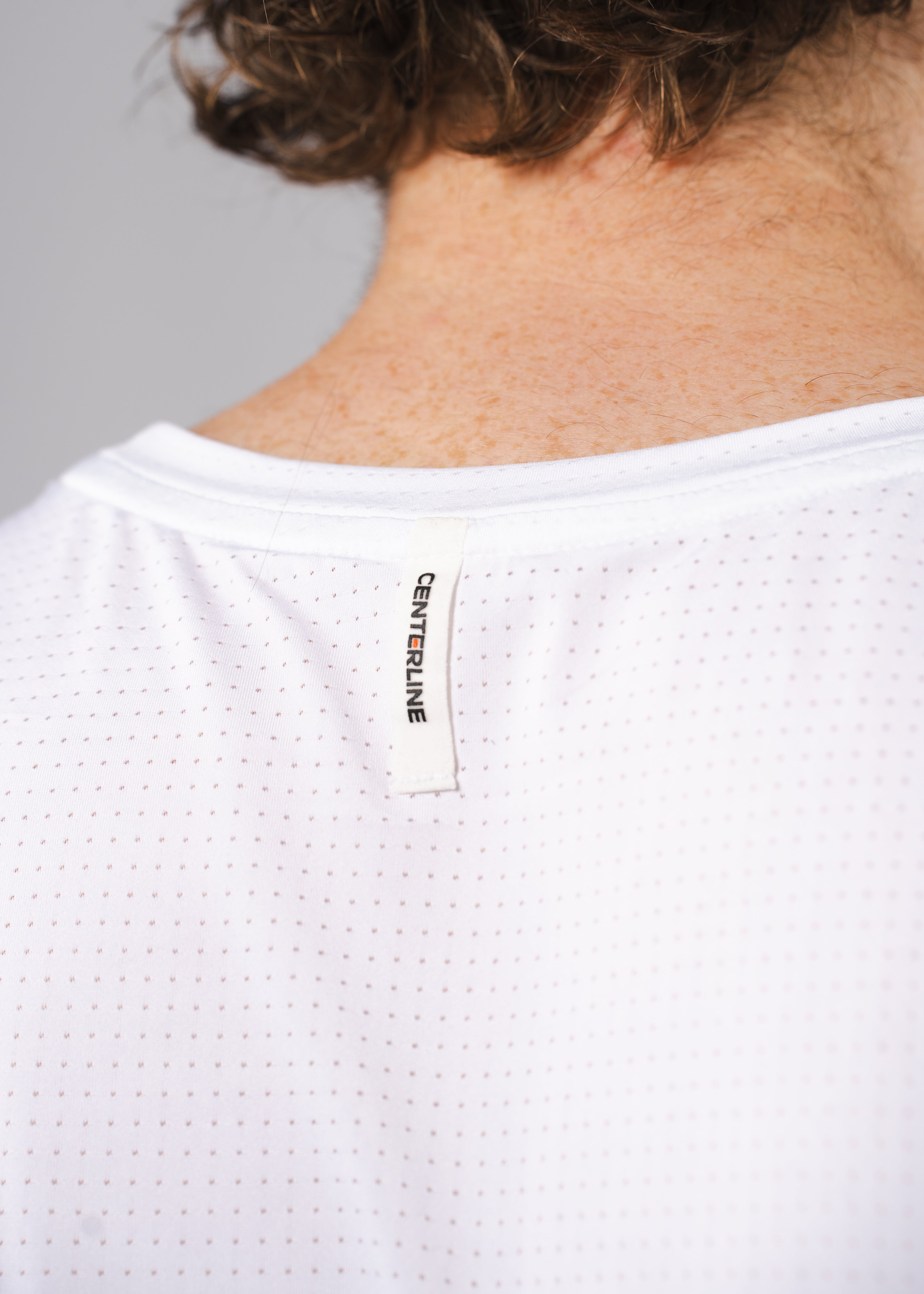 Close-up of a white athletic shirt with a "CENTERLINE" tag on the back.