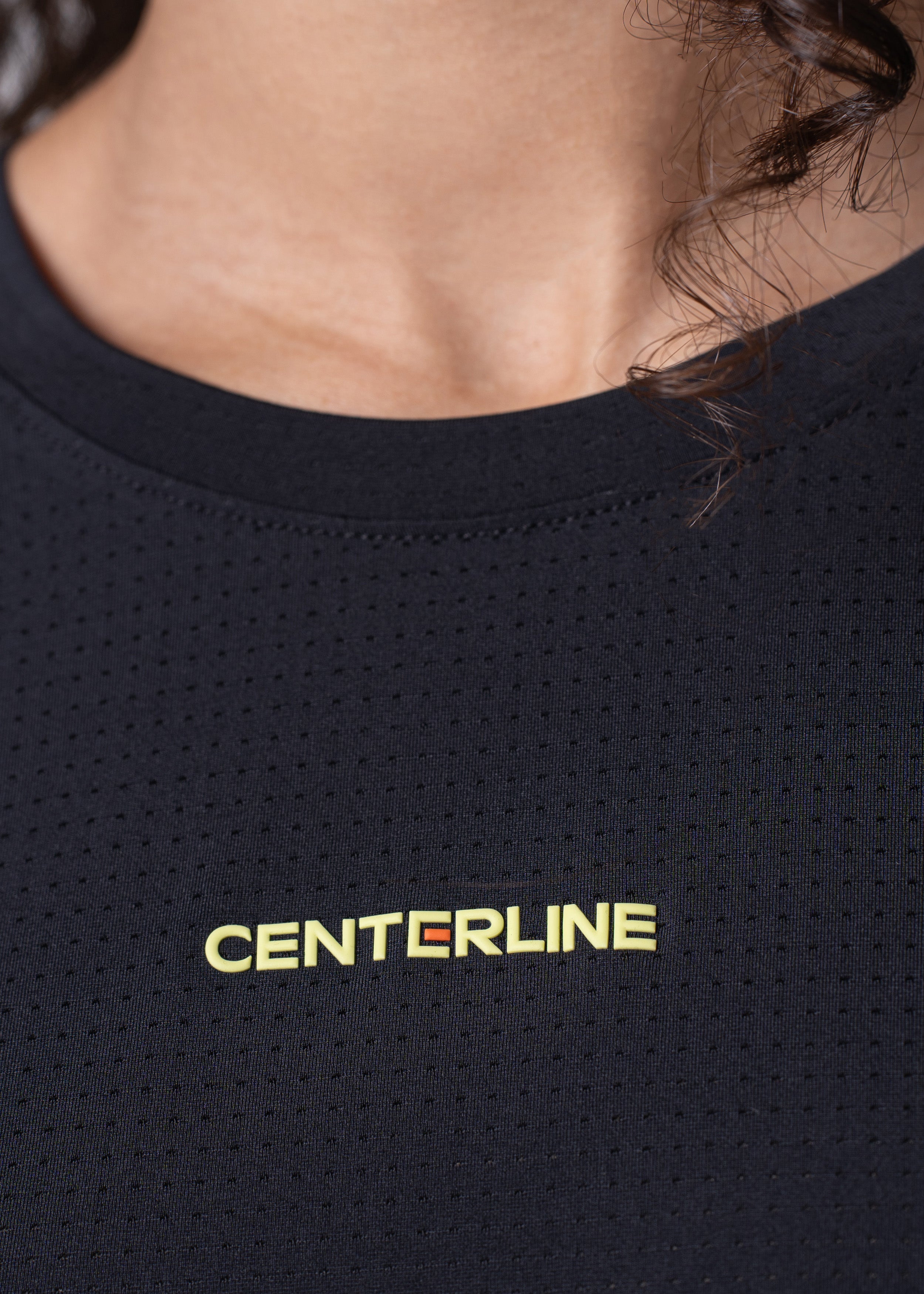 Close-up of a black mesh shirt with "CENTERLINE" in yellow letters.