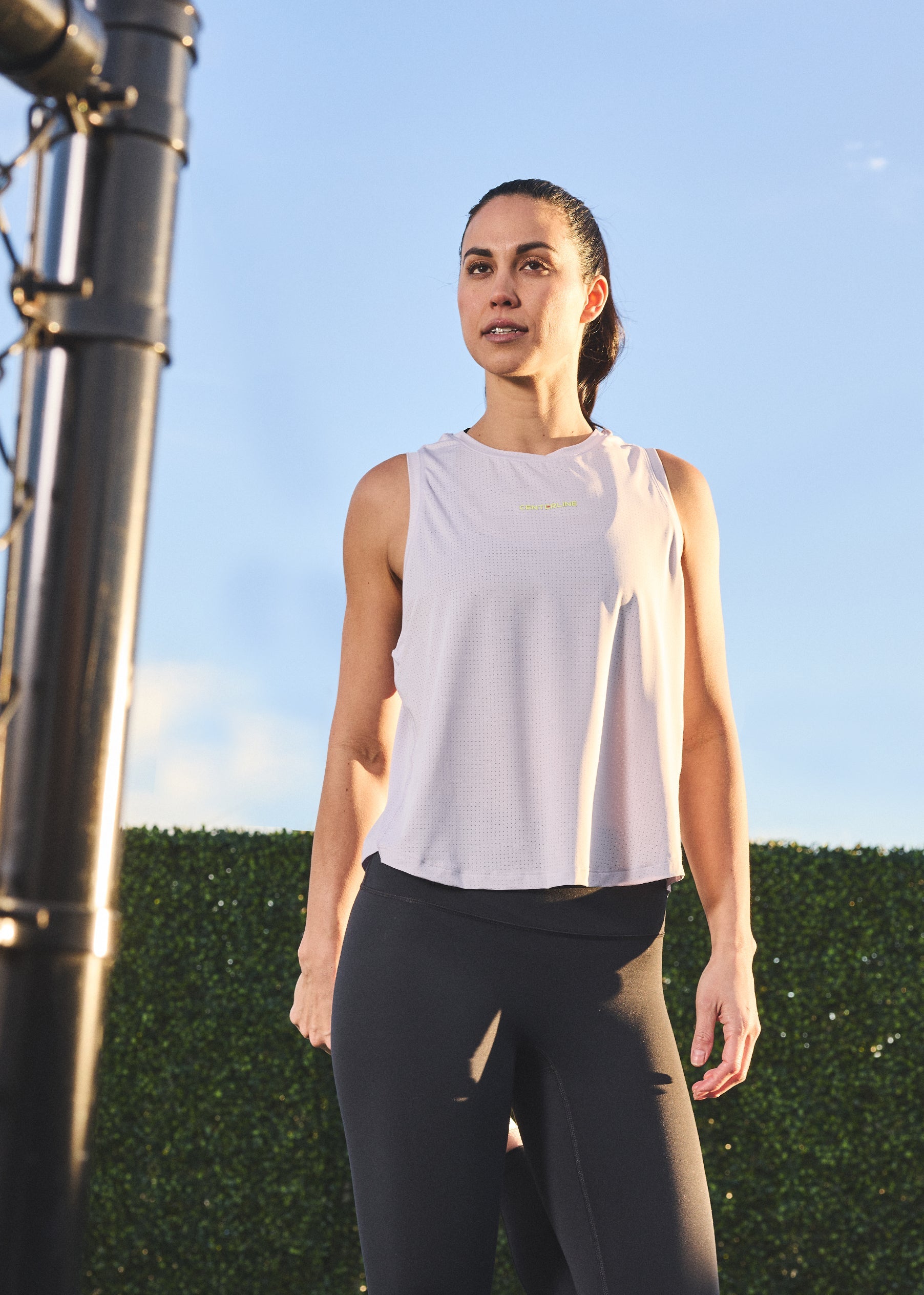 Woman in activewear tank top and leggings.
