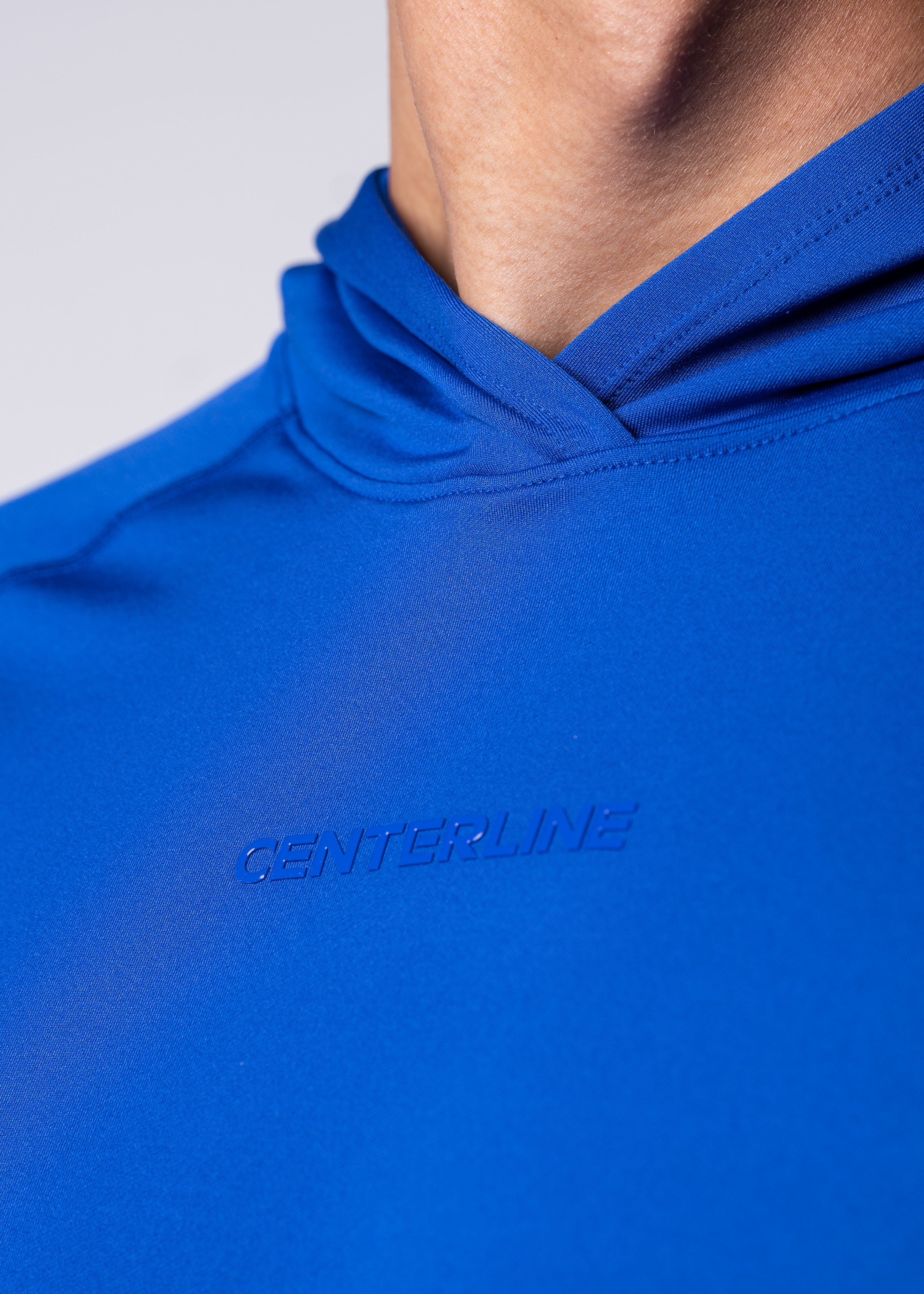 Close-up of a blue hooded athletic shirt with embossed "CENTERLINE" logo.
