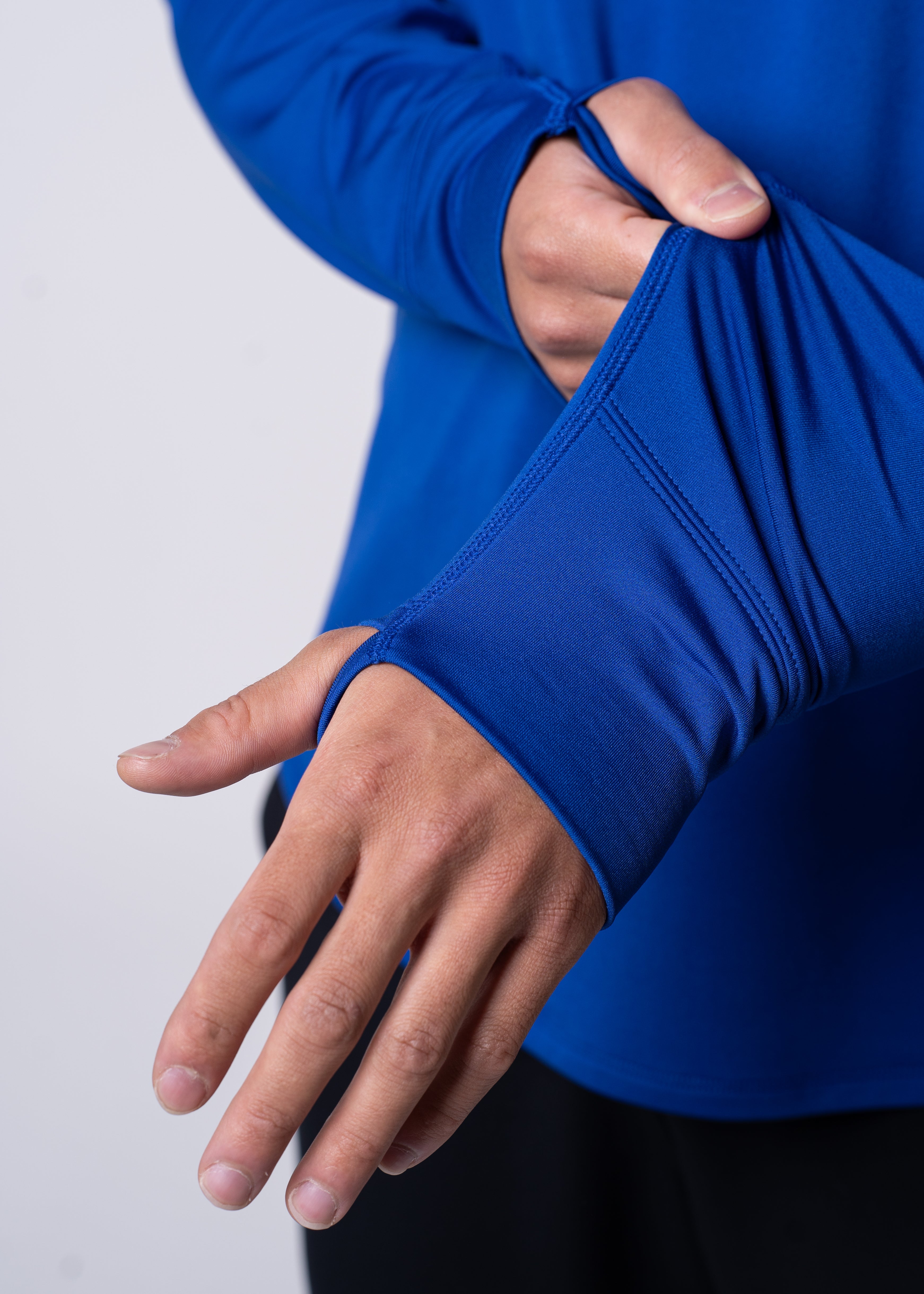 Person wearing a blue long sleeve thumbhole shirt.