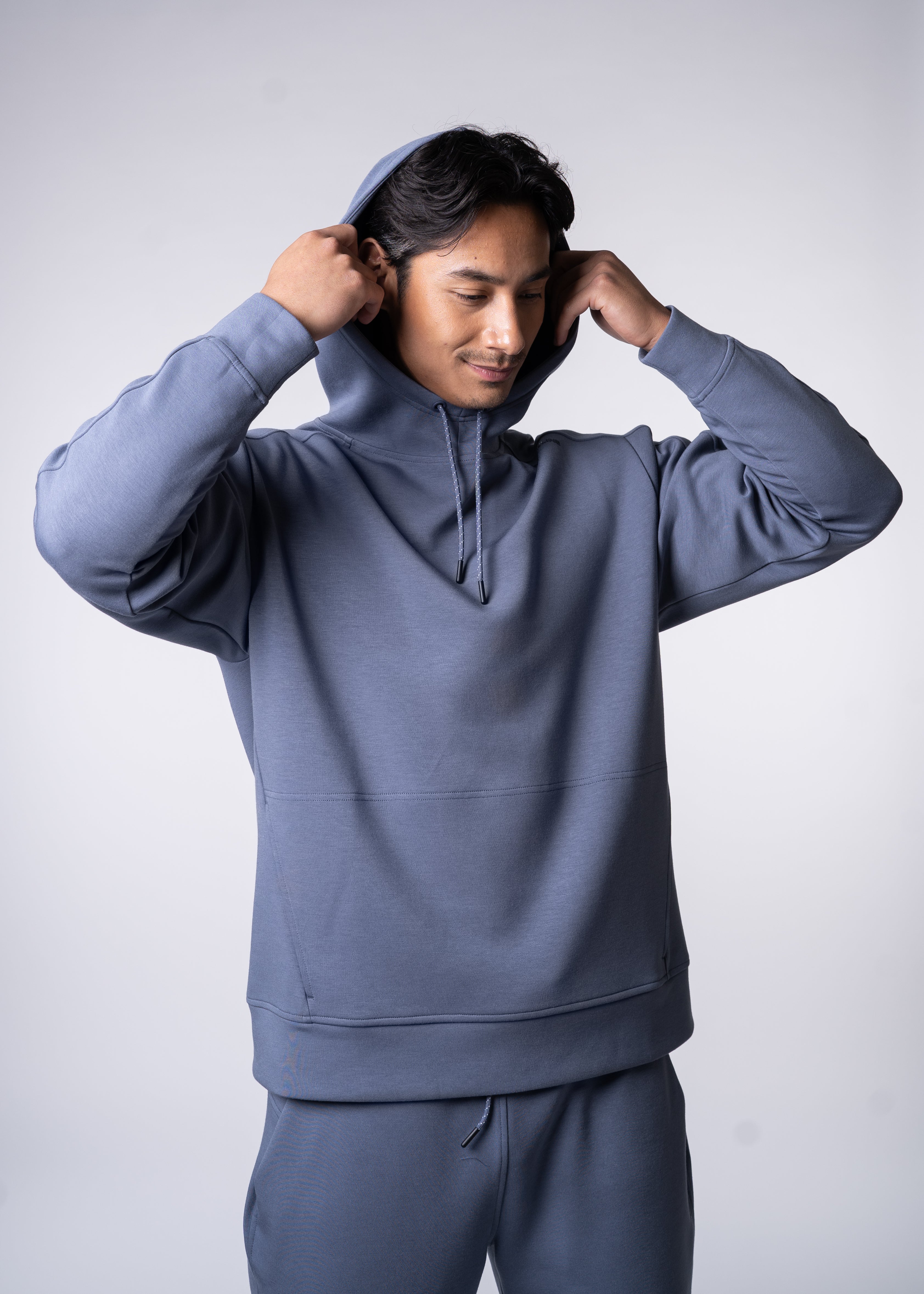 A man in a light blue hoodie and sweatpants.