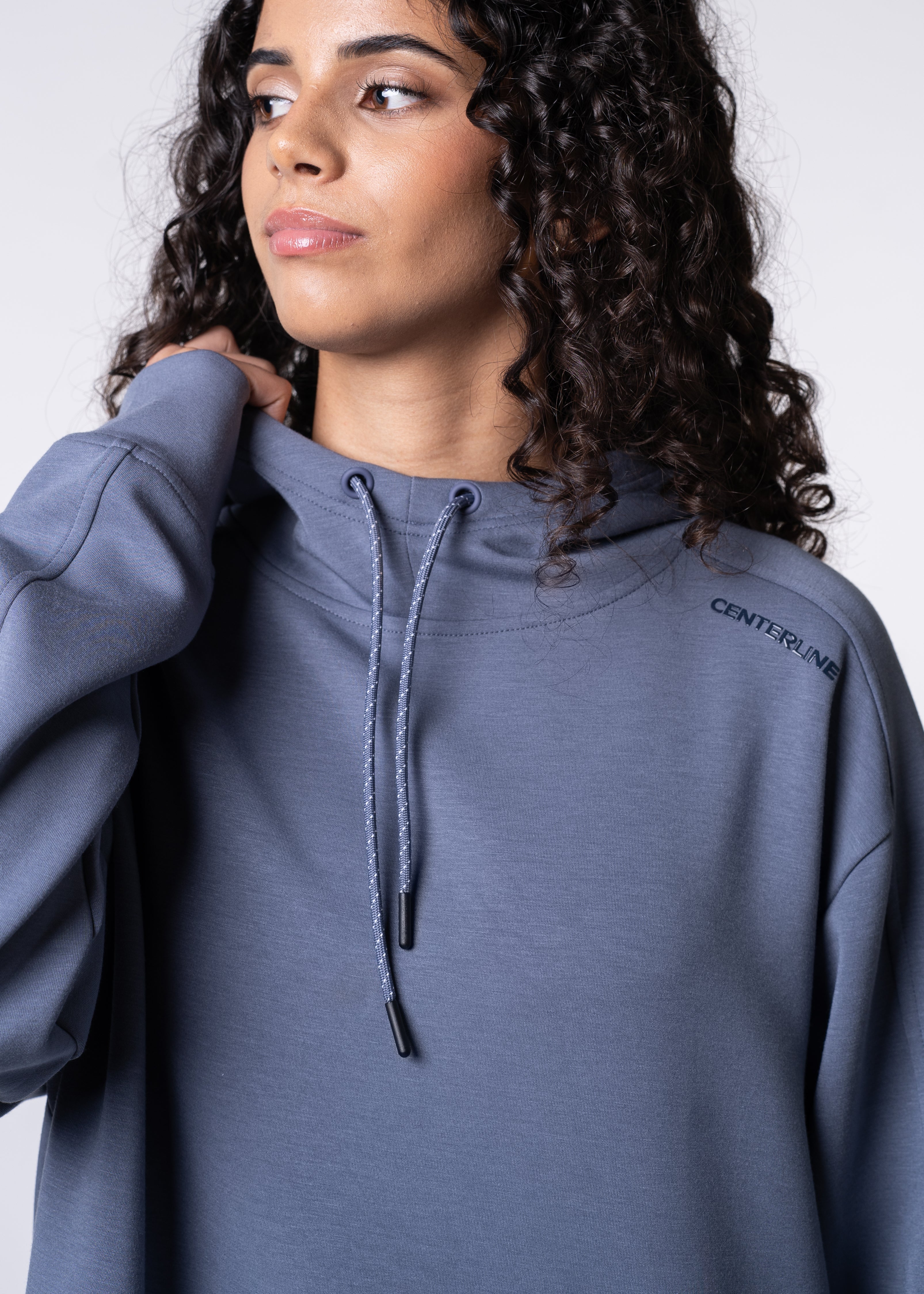 Woman wearing a blue hooded sweatshirt with drawstring.