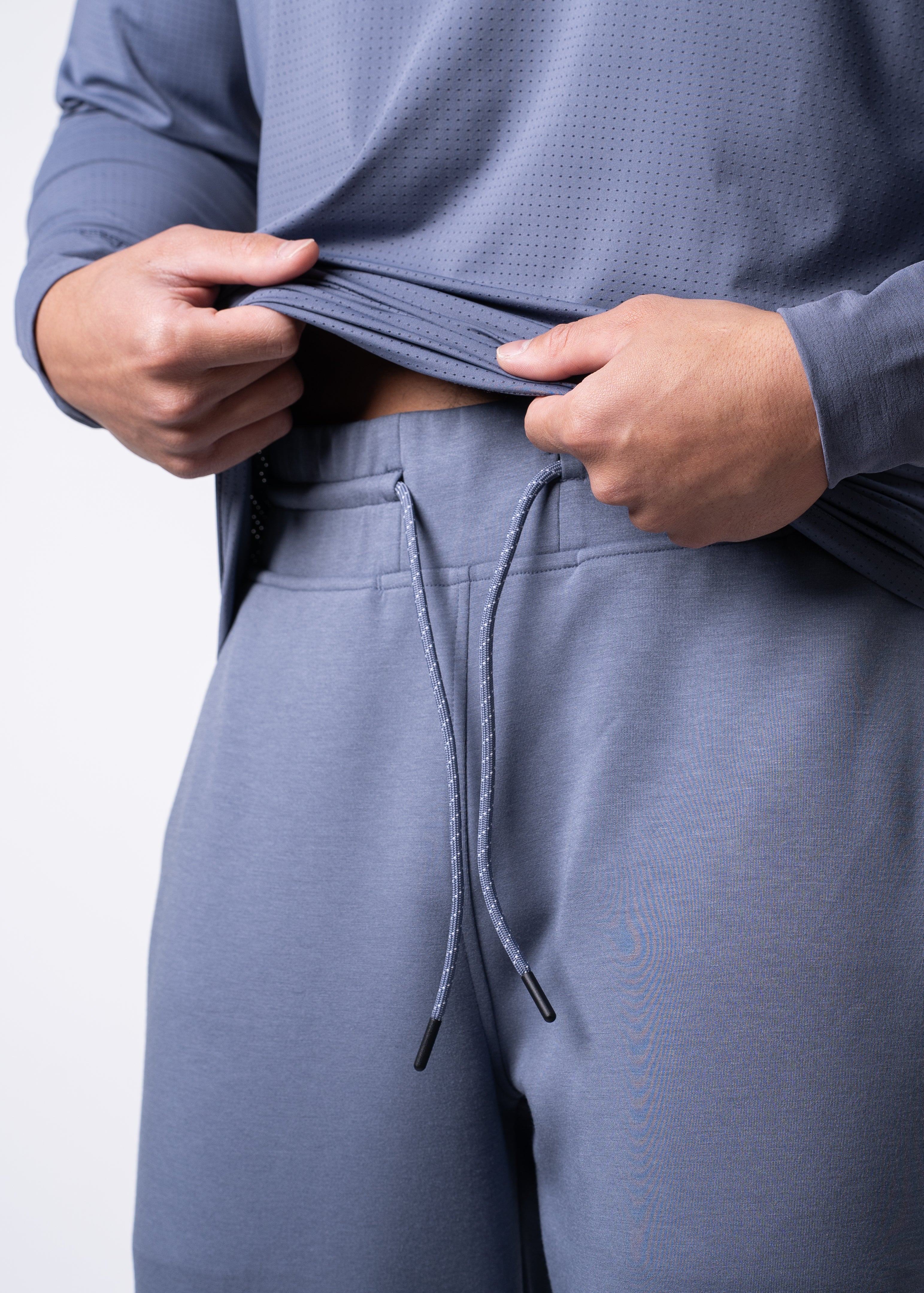 Person in blue athletic wear with drawstring pants.