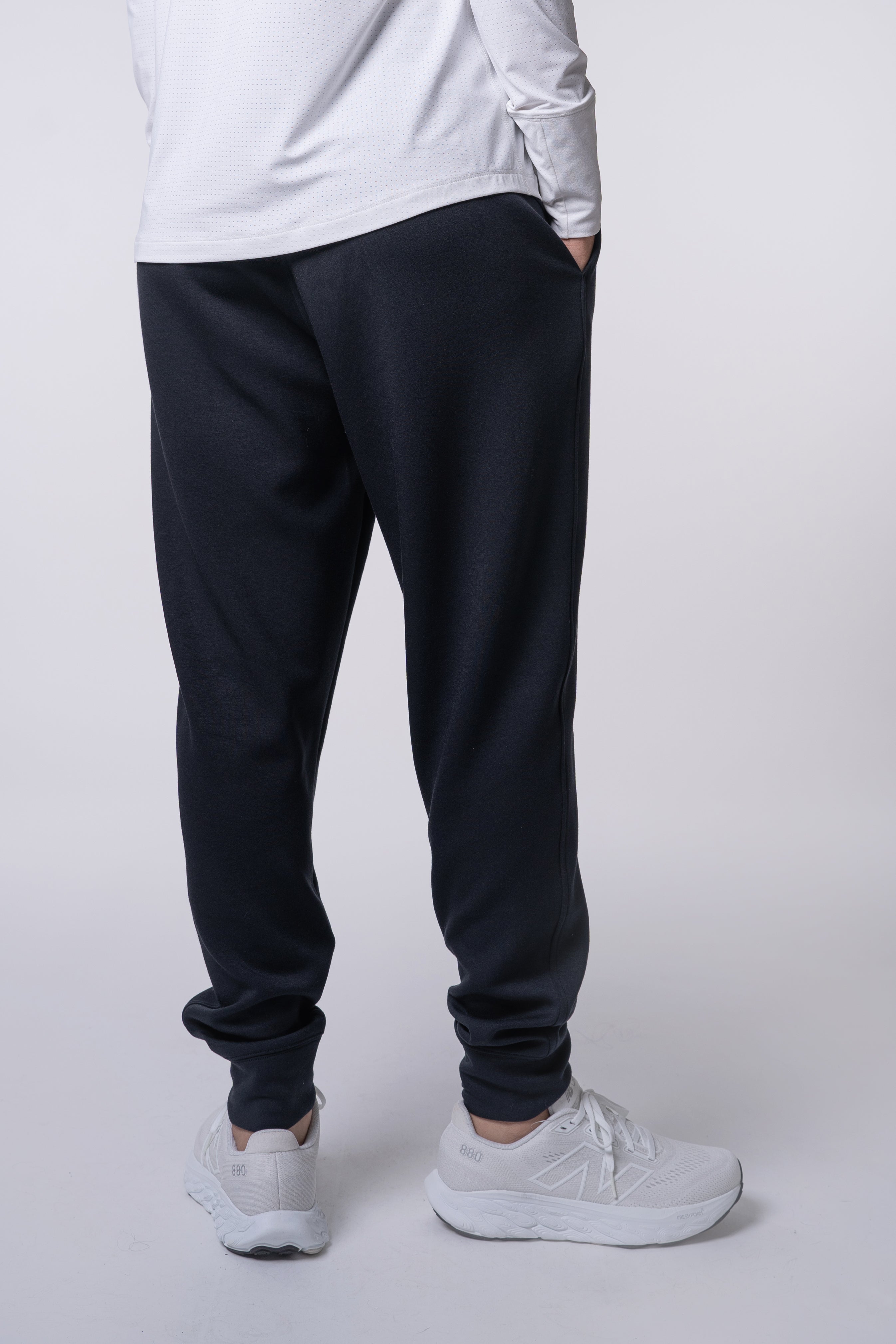 Person in white shirt, dark sweatpants, and white sneakers.