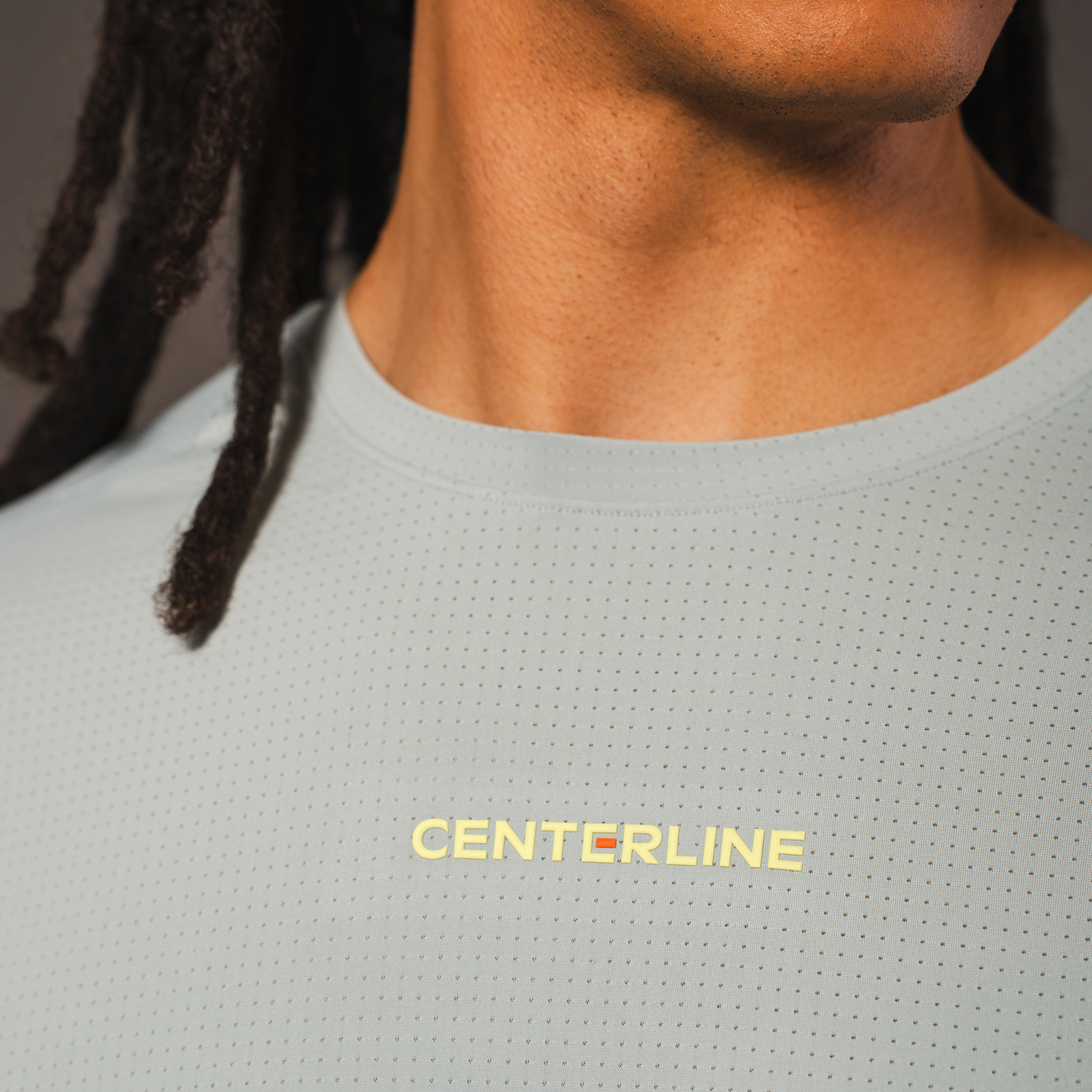 Close-up of a person wearing a light blue athletic shirt with the word "CENTERLINE" in yellow.