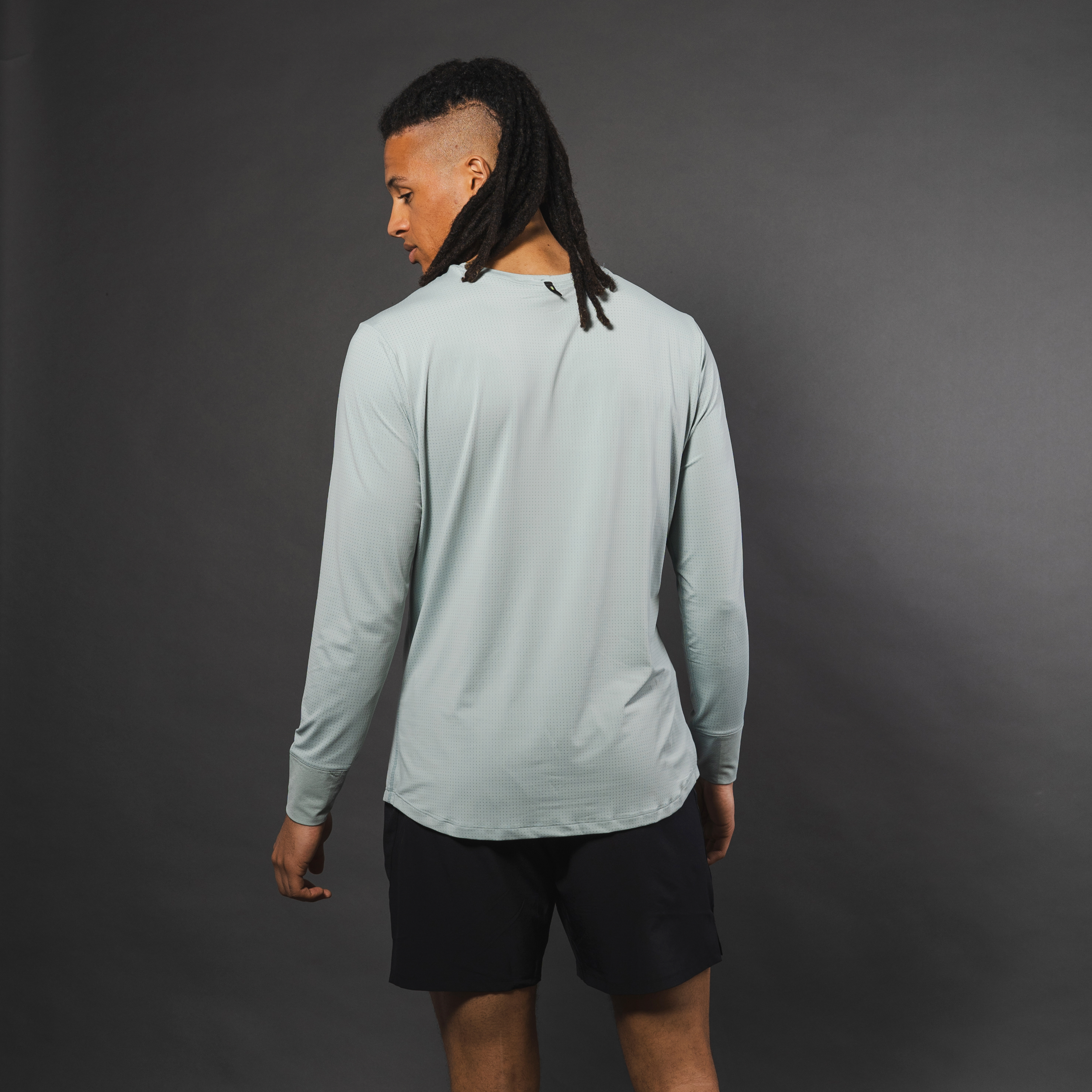 Man from behind in long-sleeve gray athletic shirt and black shorts.