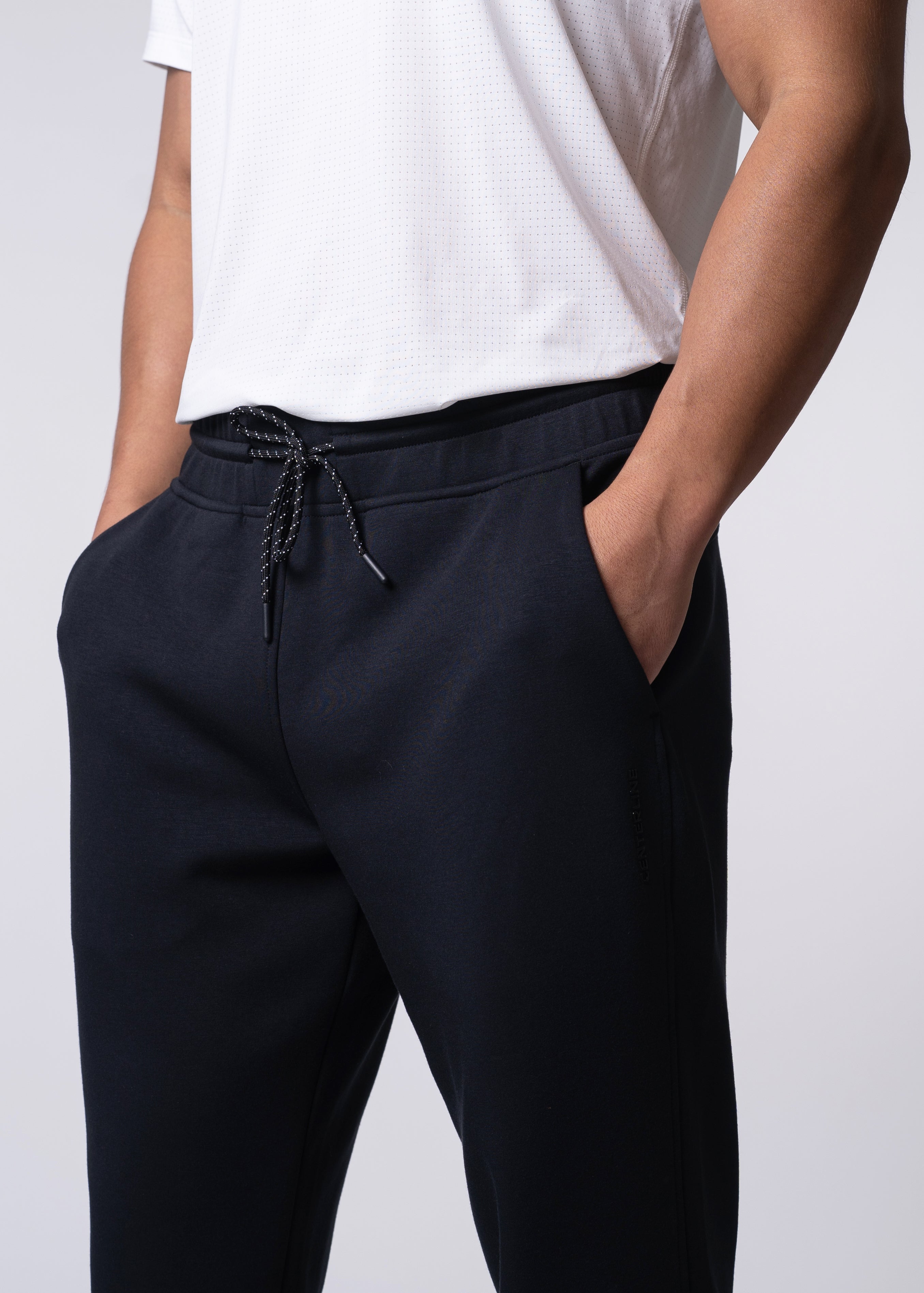 Person in white shirt and black sweatpants.