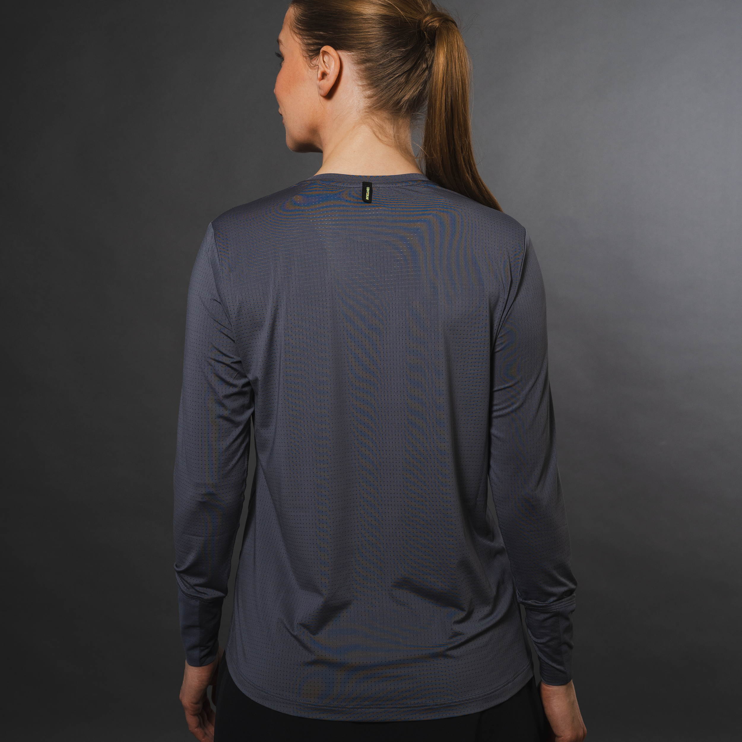 Woman in gray long-sleeve shirt facing away.