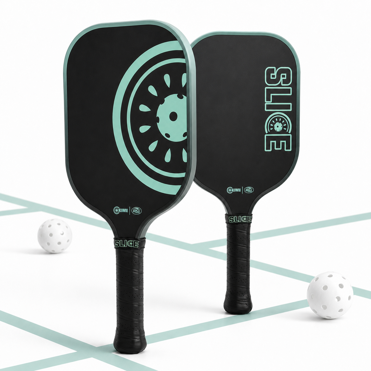 Two black and mint green carbon fiber pickleball paddles by Kiwi Labs Pickleball, one with a kiwi fruit design and the other 'SLICE' text, with two white pickleballs.