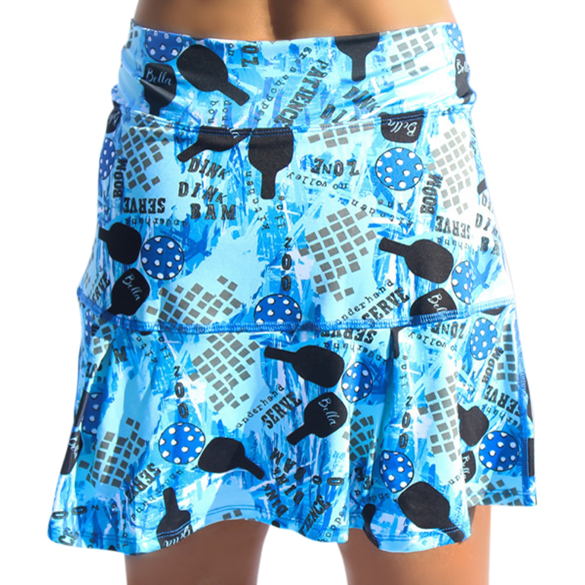 Light blue pleat skort by Pickleball Bella, featuring a blue pickleball graffiti pattern with paddles, balls, and game terms.
