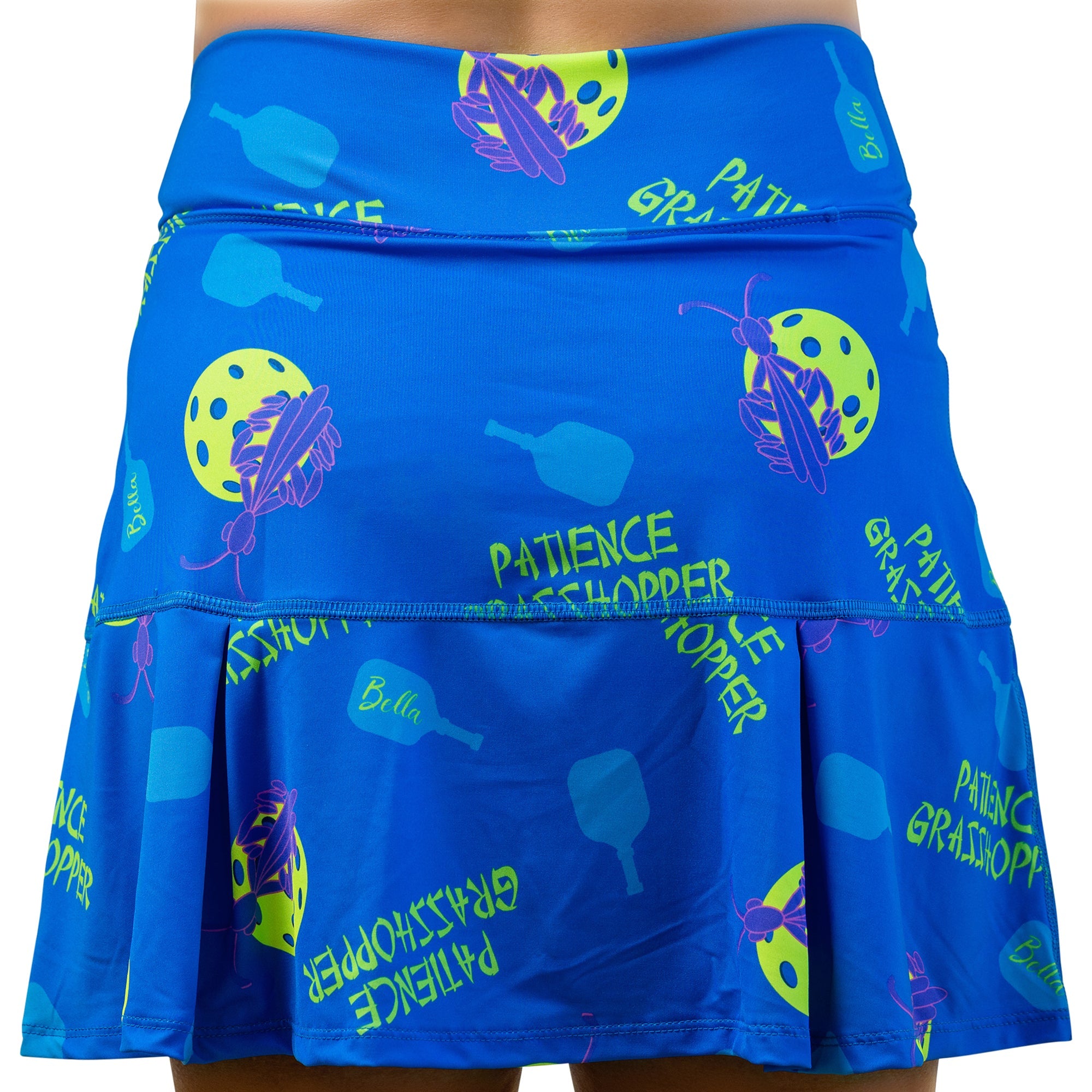 Blue drop pleat skort by Pickleball Bella with a pattern of pickleball paddles, grasshoppers, pickleballs, and "Patience Grasshopper" text.