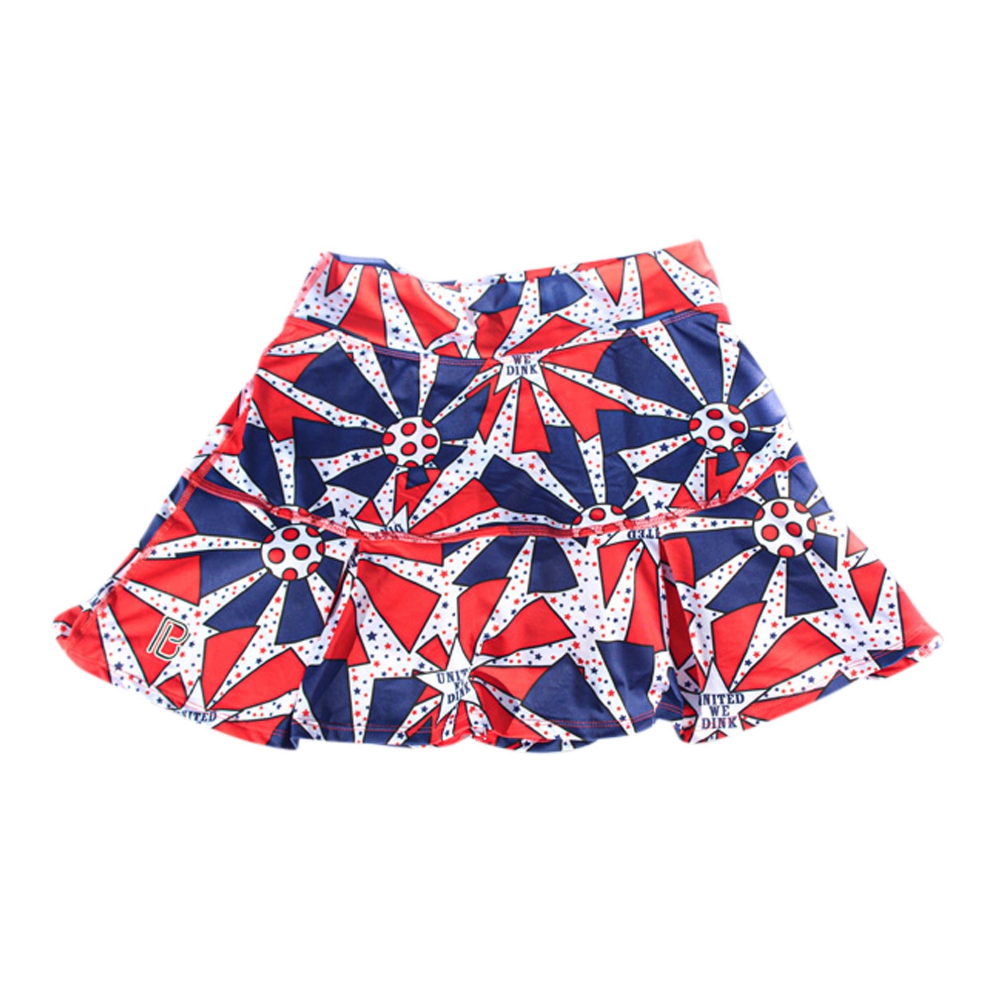 A red, white, and blue drop pleat skort by Pickleball Bella, featuring geometric stars, circles, and "United We Dink" text.