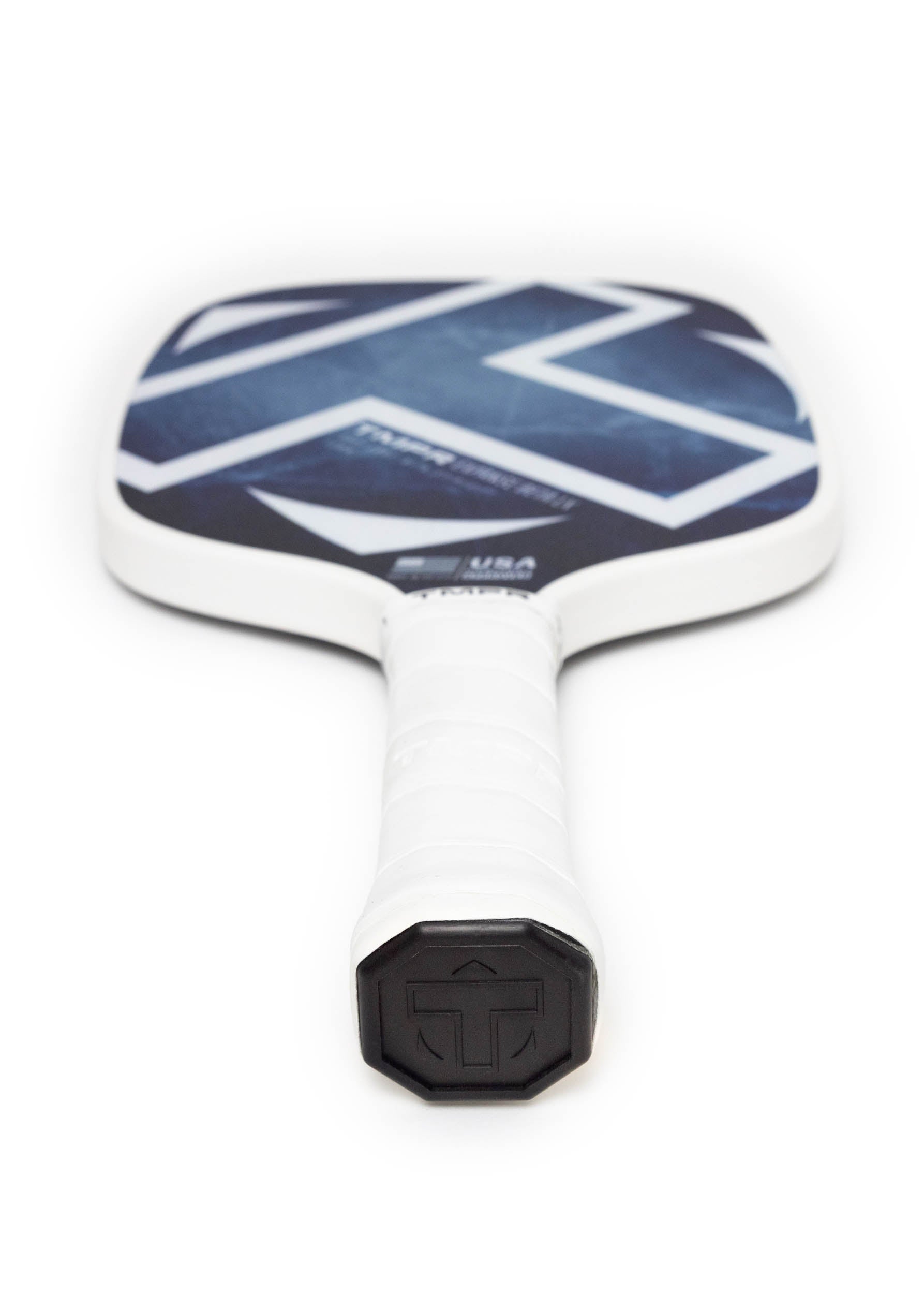 White pickleball paddle by TMPR Sports with an indigo ice geometric patterned face and black T logo on the end cap, angled.