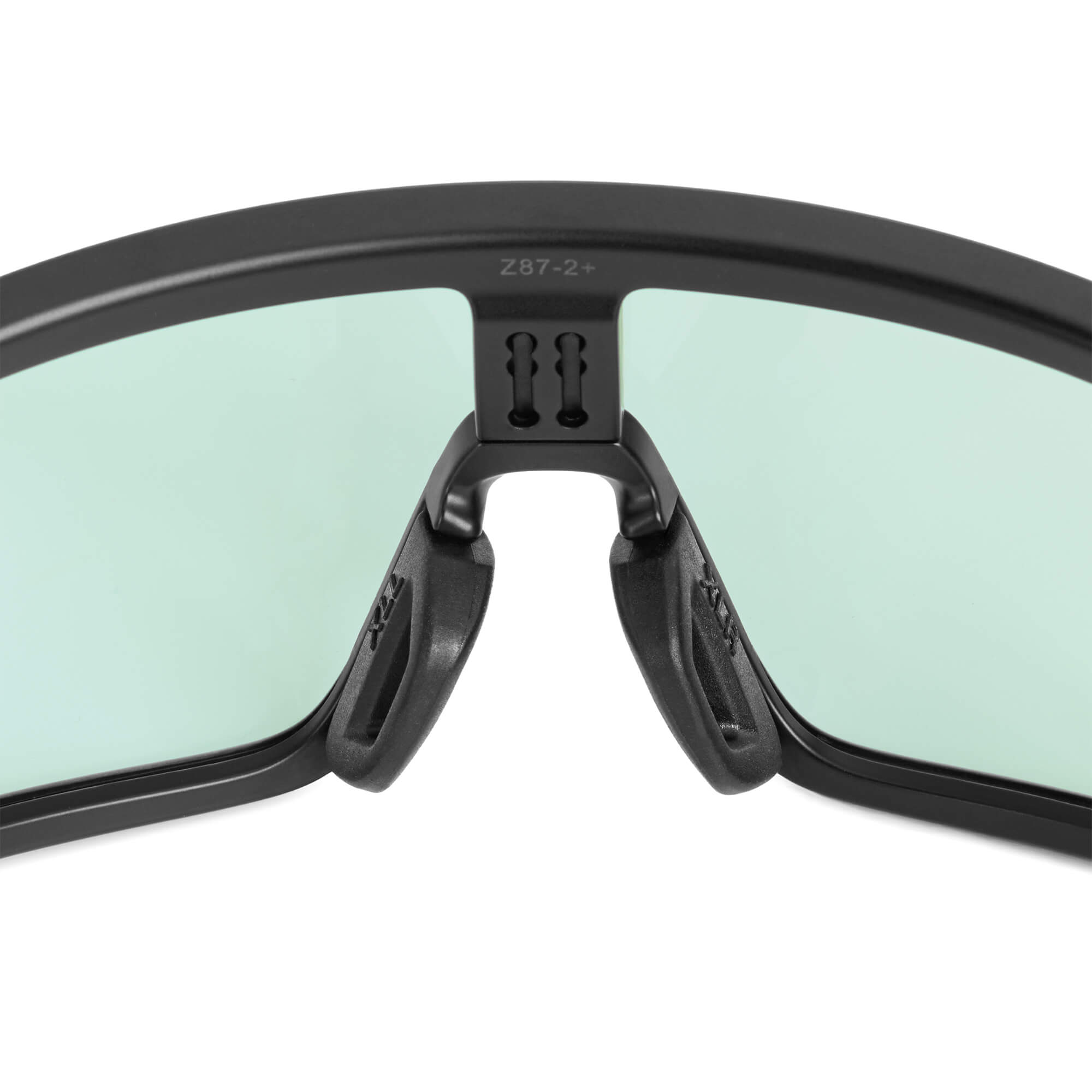 Black, textured FOCOS ANKR™ Nose Pads by BRIOTI, attached to sunglasses with green lenses and a "Z87-2+" marking.