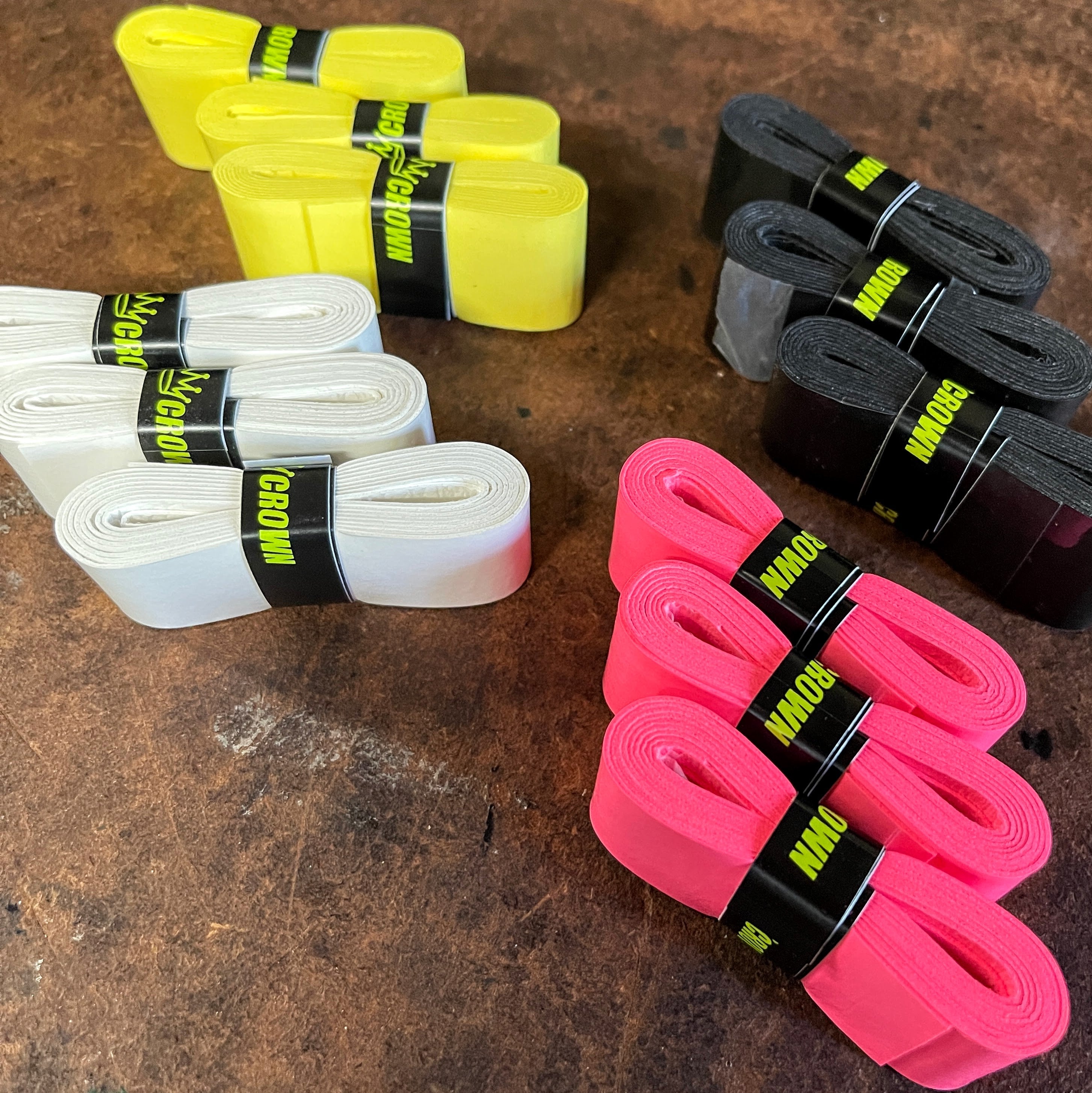 Packs of neon yellow, white, black, and pink "Crown" brand athletic grip tape.