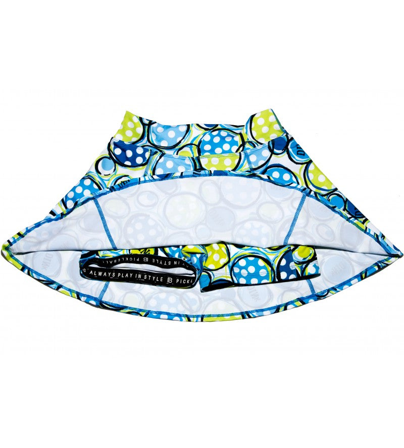 A-line skort in blue and lime green with a bubble pattern by Pickleball Bella, shown upside-down revealing built-in shorts with inner waistband text.