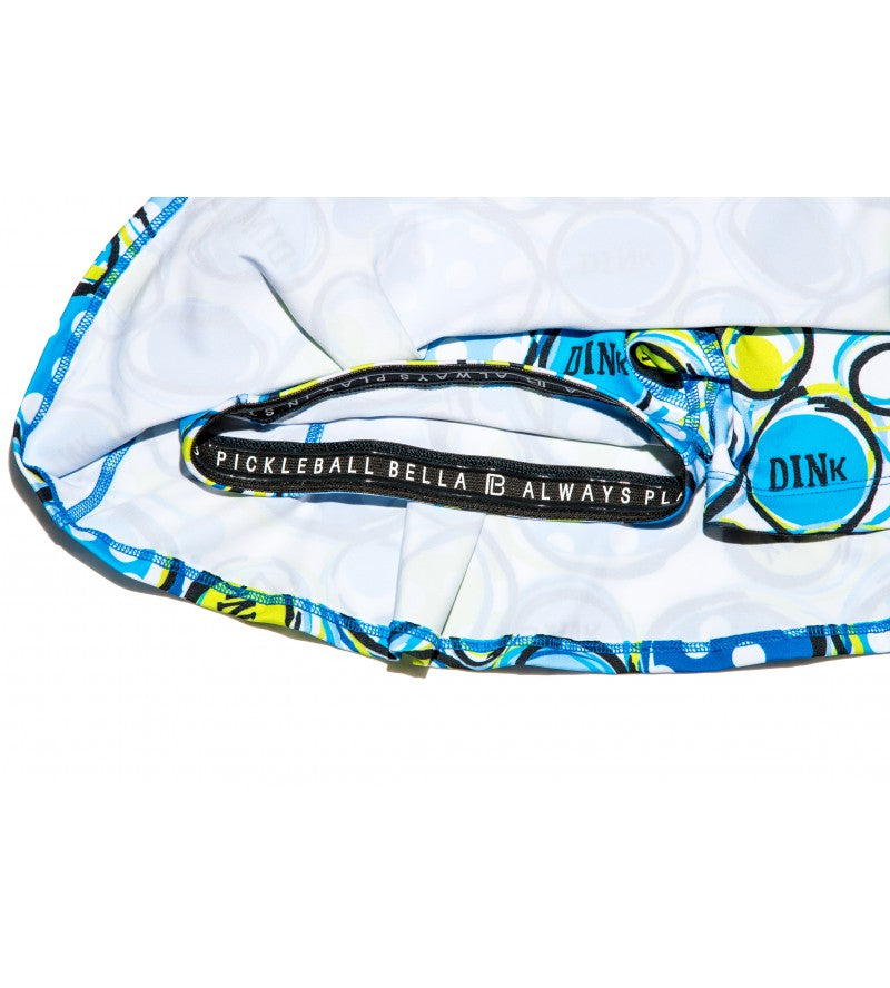 Blue, white, and yellow patterned pleat skort by Pickleball Bella, featuring inner shorts, a black logo waistband, and outer 'DINK' circles.