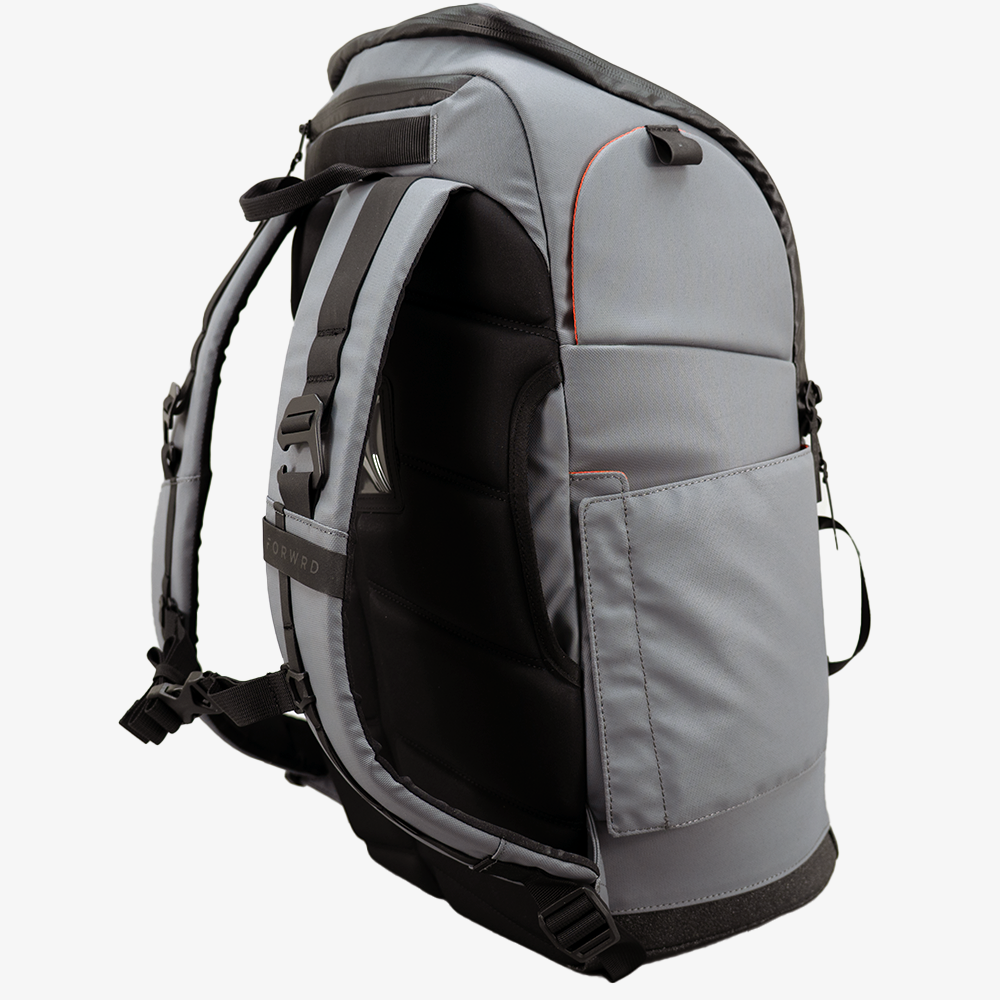 Grey pickleball backpack by FORWRD with black padded straps and back, orange piping, and a side pocket, 'FORWRD' visible on strap.