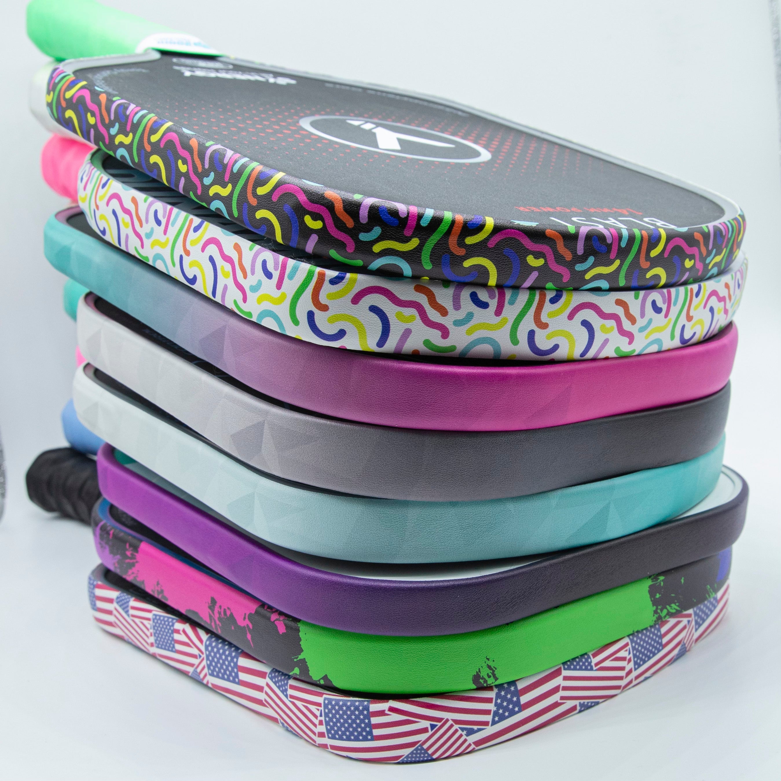 Stack of colorful pickleball paddles.