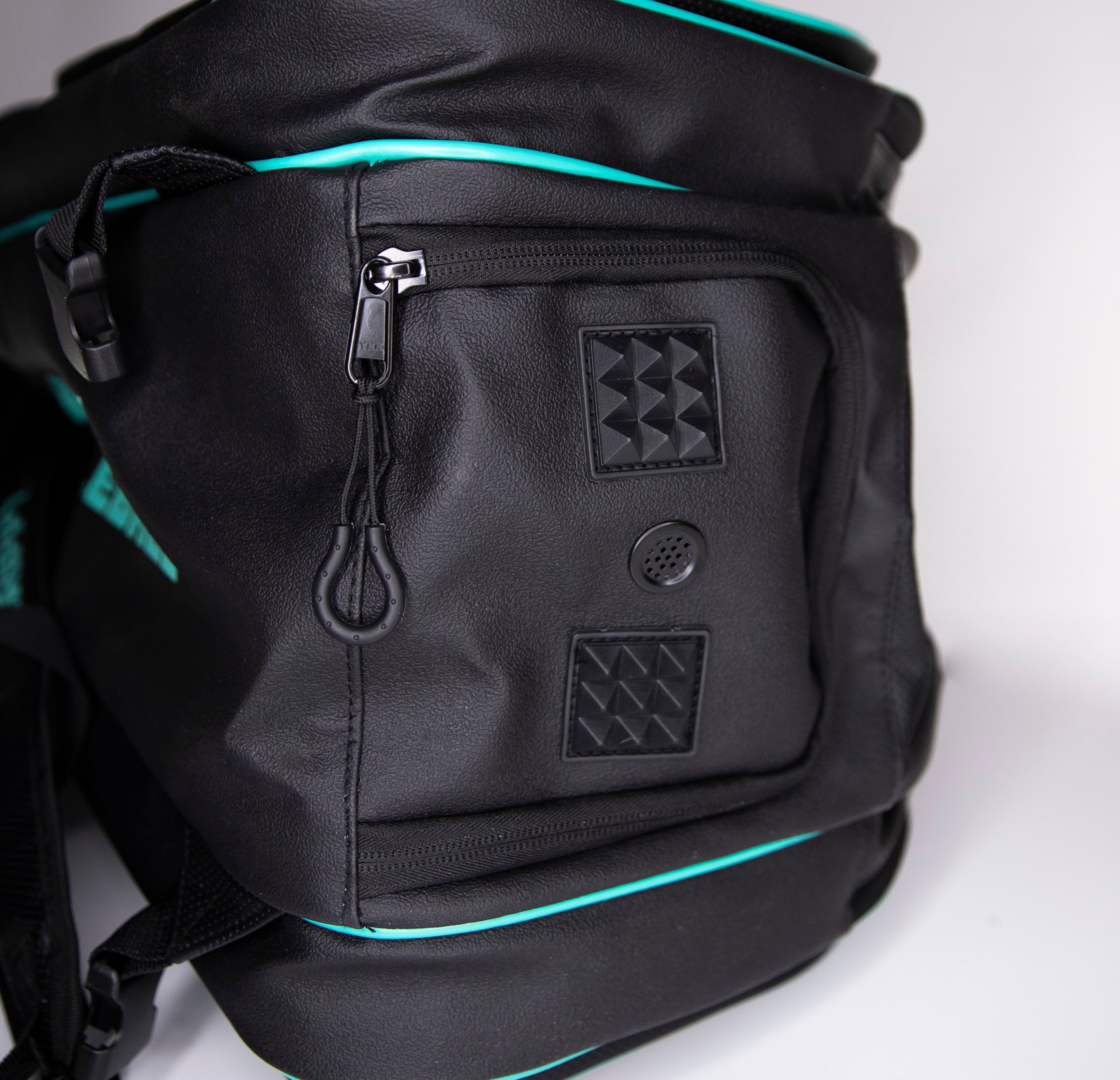 Close-up of a black backpack with turquoise trim.