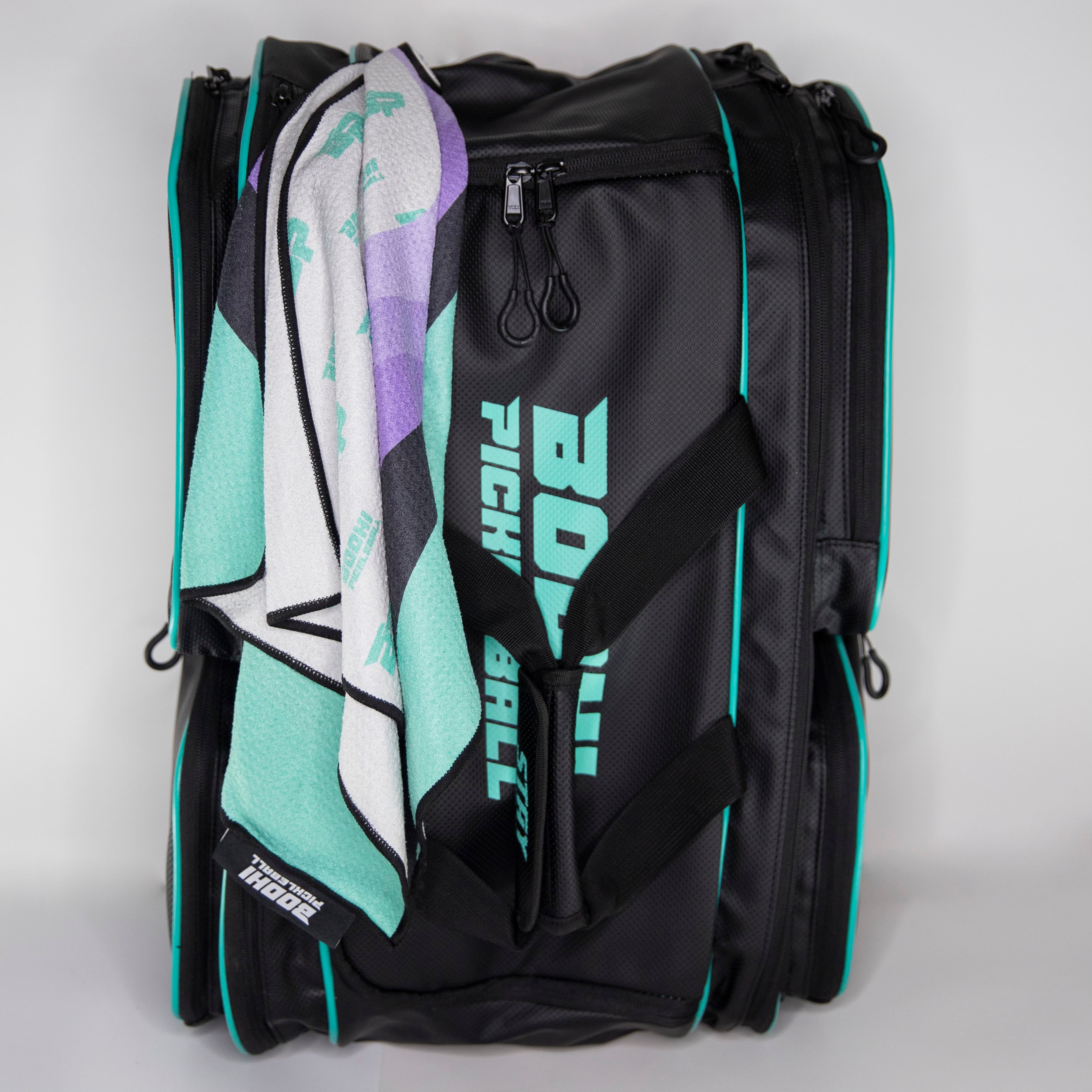 Black pickleball backpack with turquoise accents and a towel.