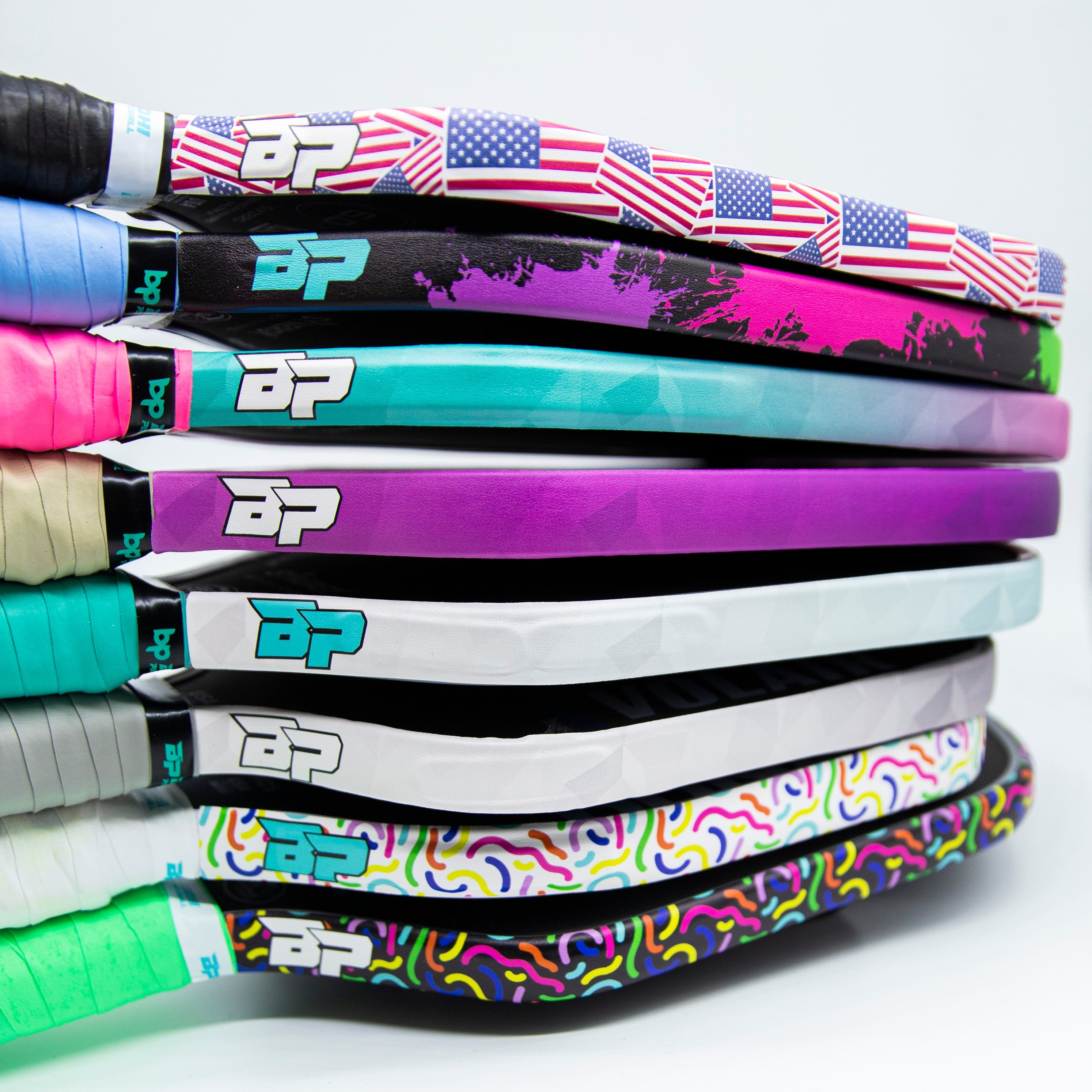 Stack of colorful pickleball paddles.