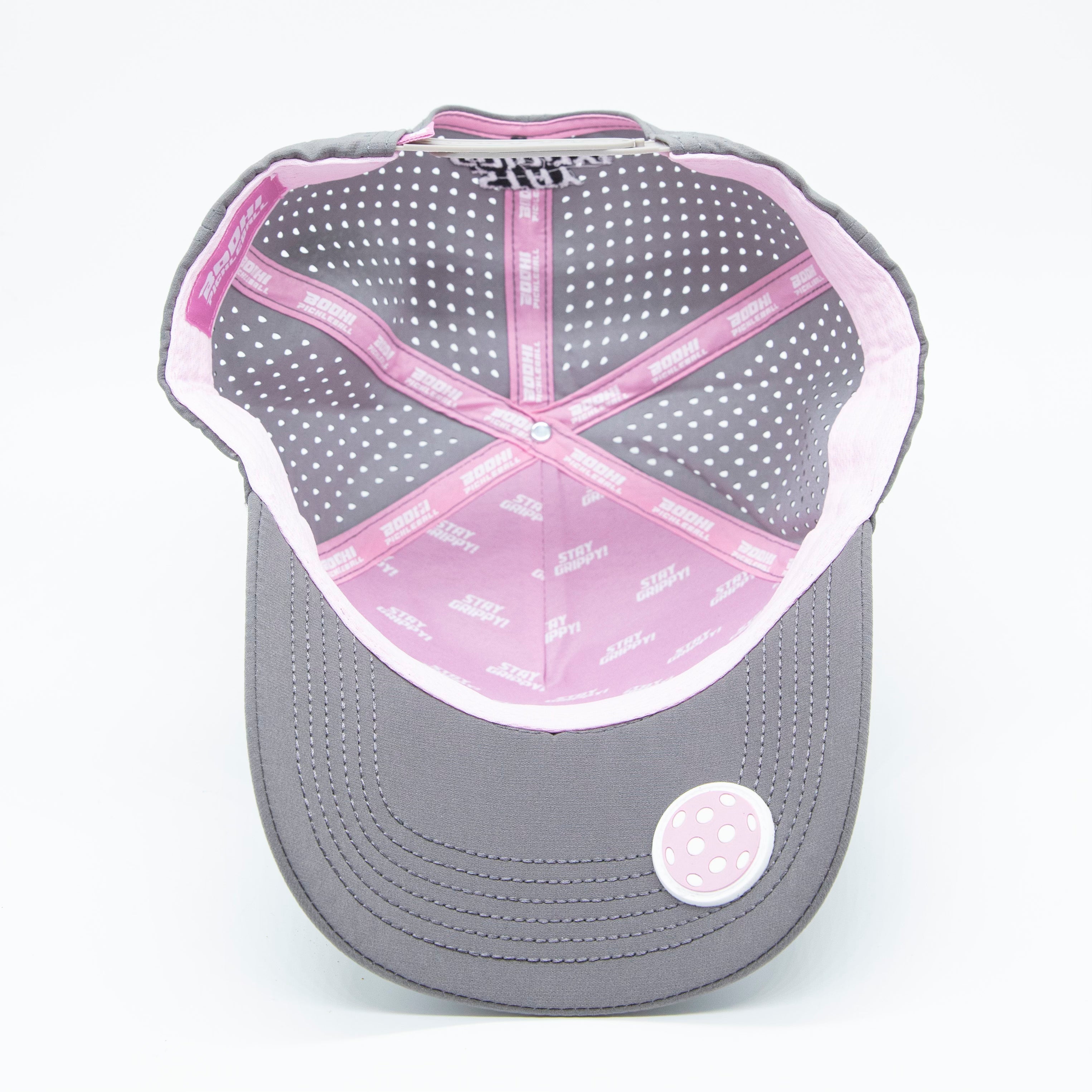 Gray baseball cap with pink trim and white polka dot lining.