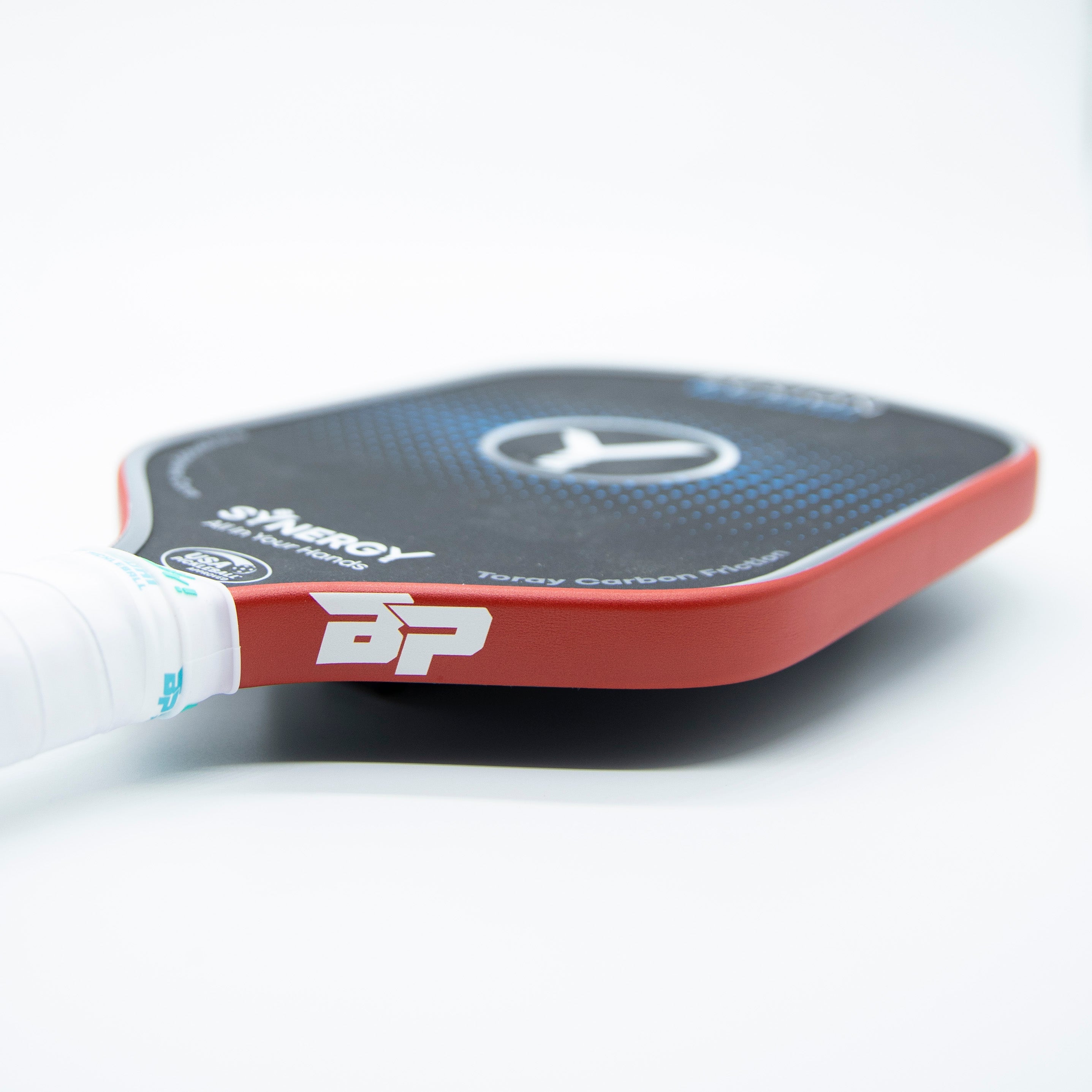 Red pickleball paddle edge tape by DinkersAlley.com with a visible BP logo, on a black paddle with white grip.