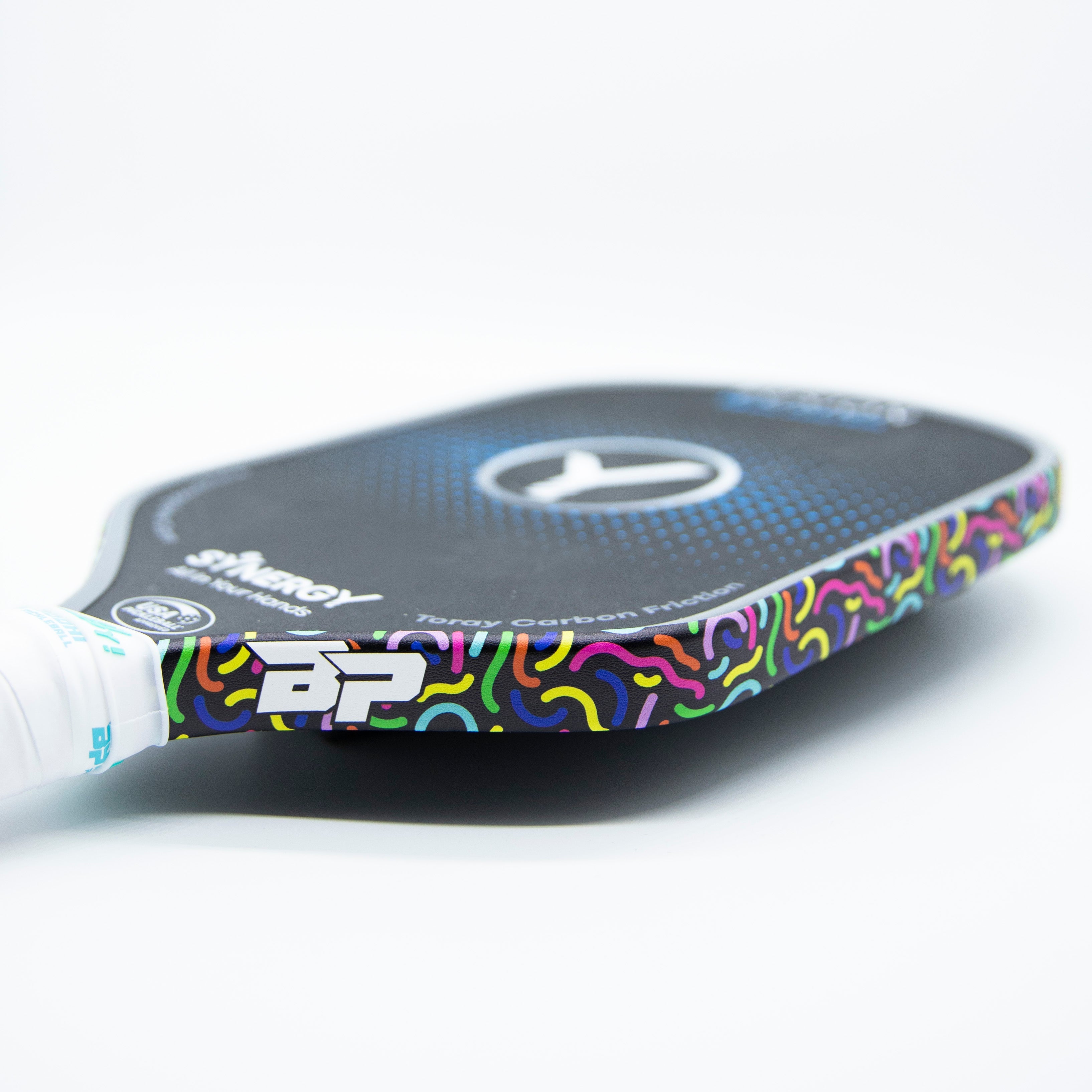 Close-up of a black pickleball paddle with colorful confetti-like patterns.